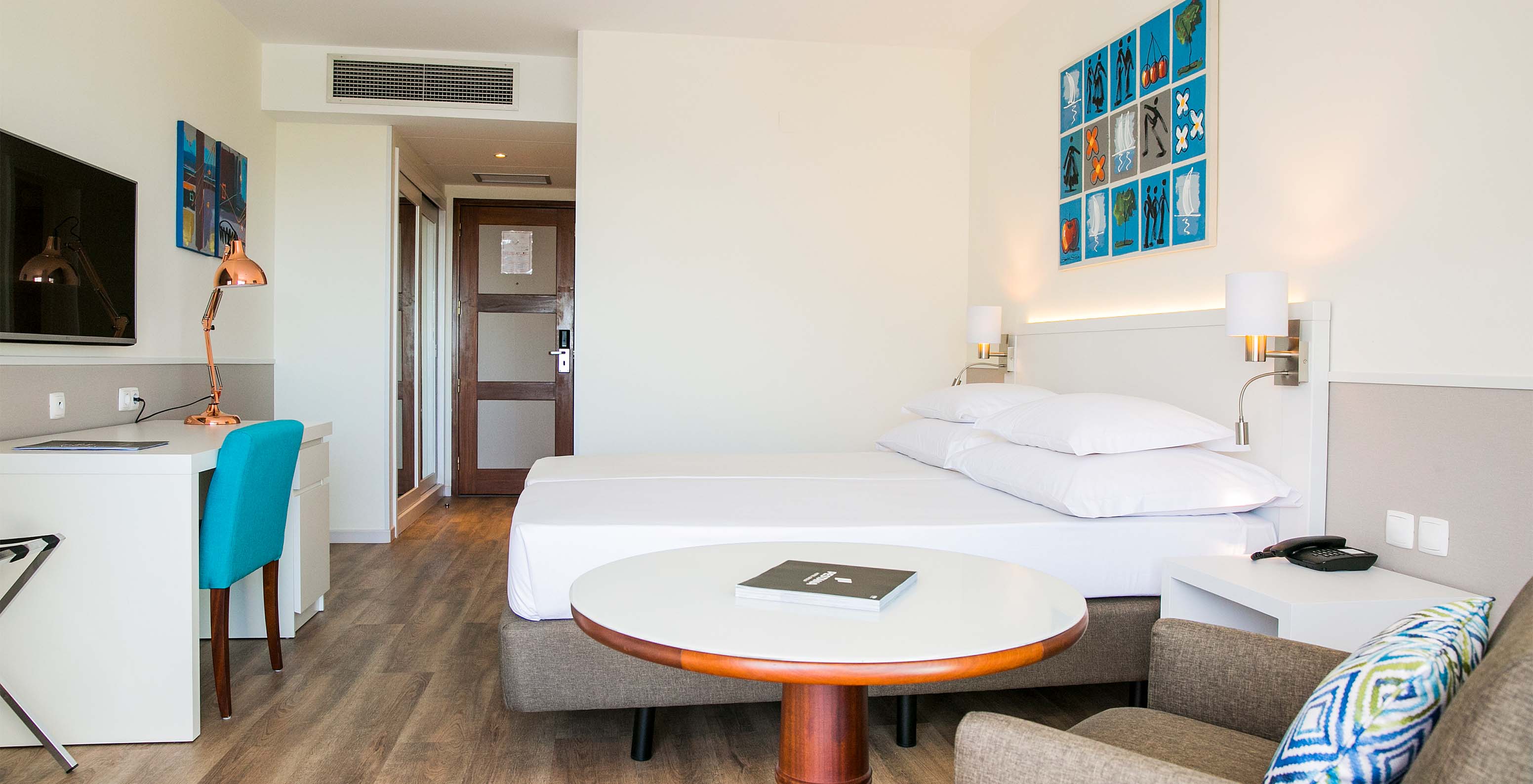 The Superior Deluxe room at Pestana Cascais has two single beds, a TV, a desk, and a kitchen