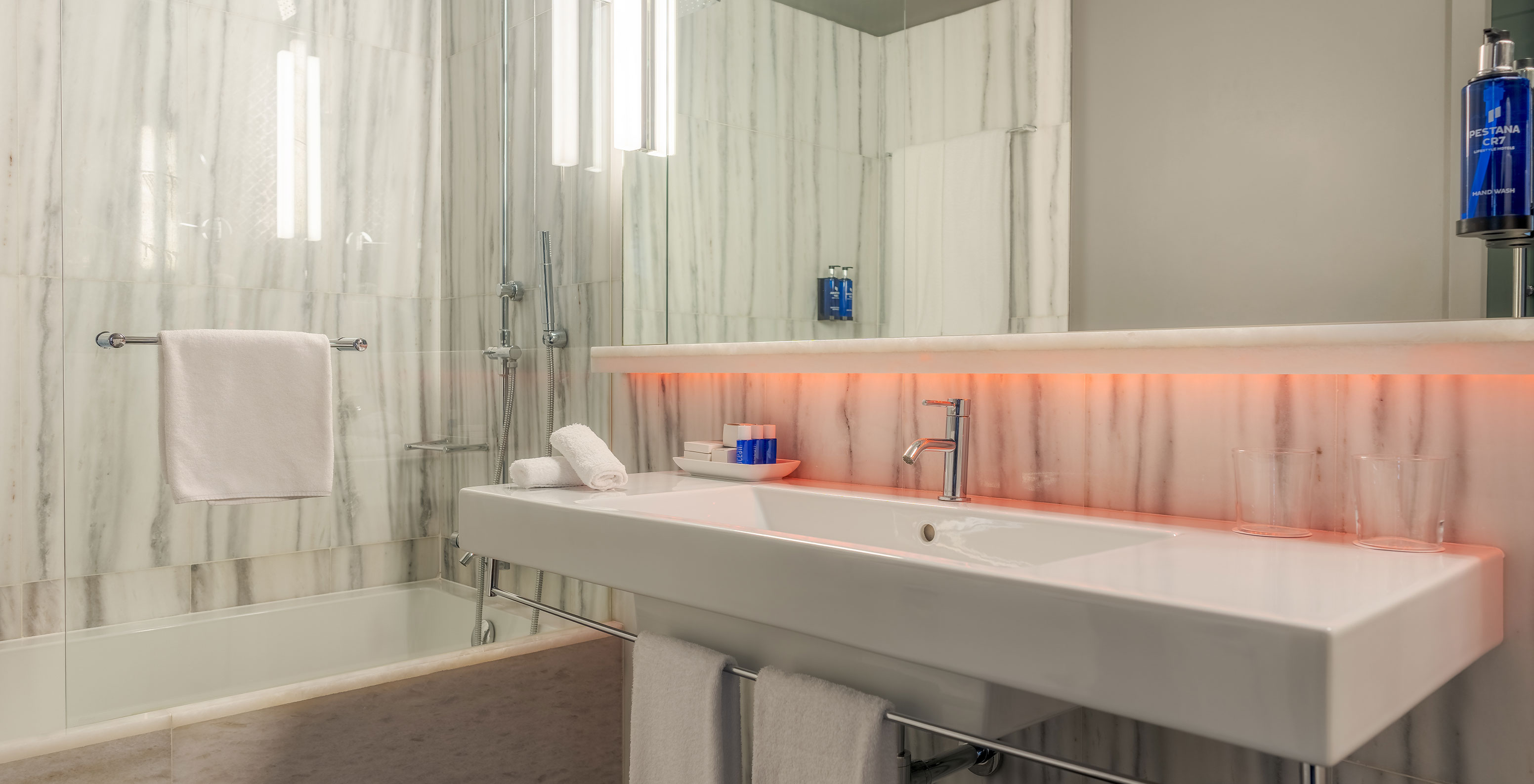 The CR7 Family Hat-Trick Room at Pestana CR7 Lisboa features a bathroom with mirror, sink, and bathtub with shower