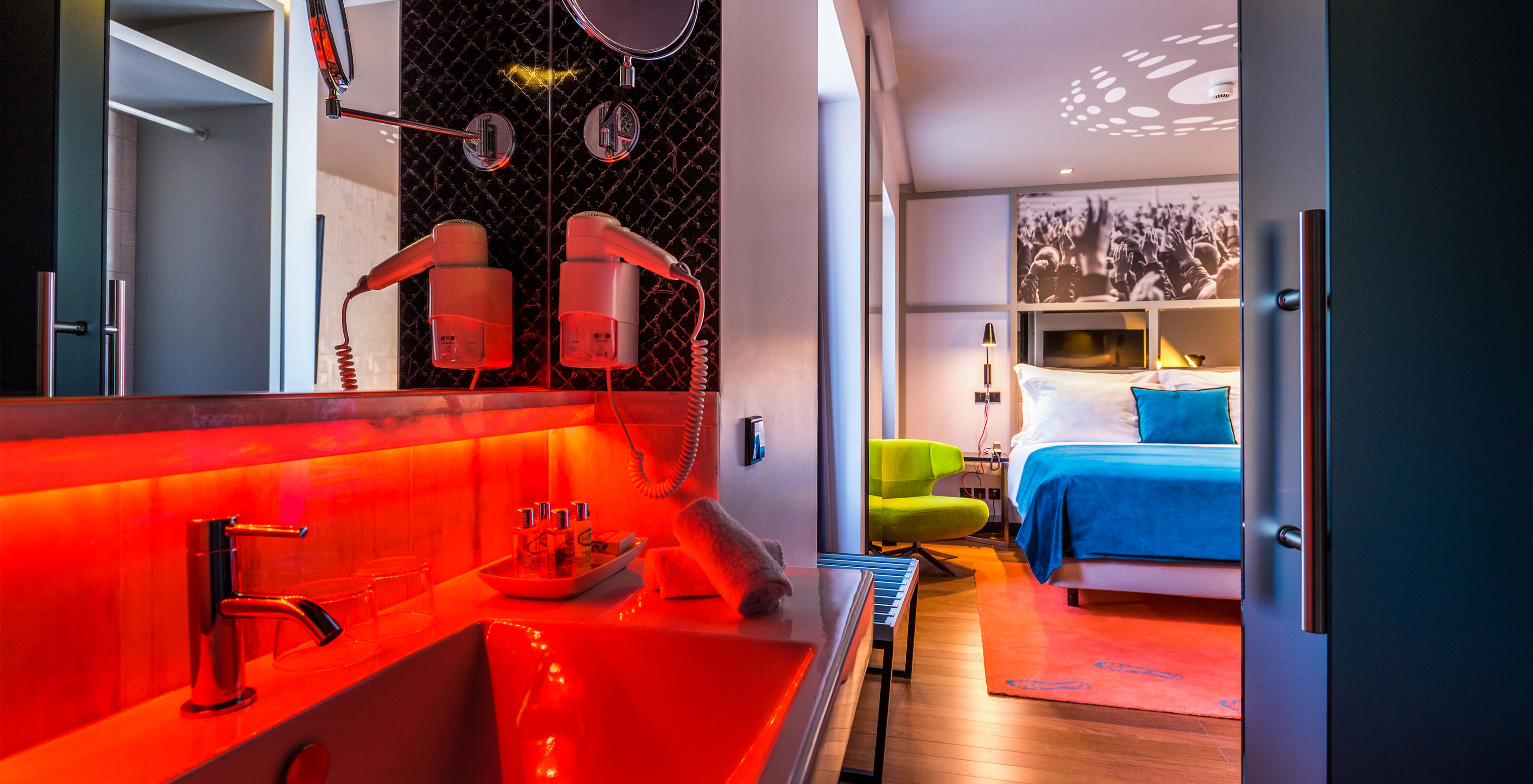 The CR7 Room at Pestana CR7 Lisboa features a double bed and a bathroom with sink, mirror, and hairdryer