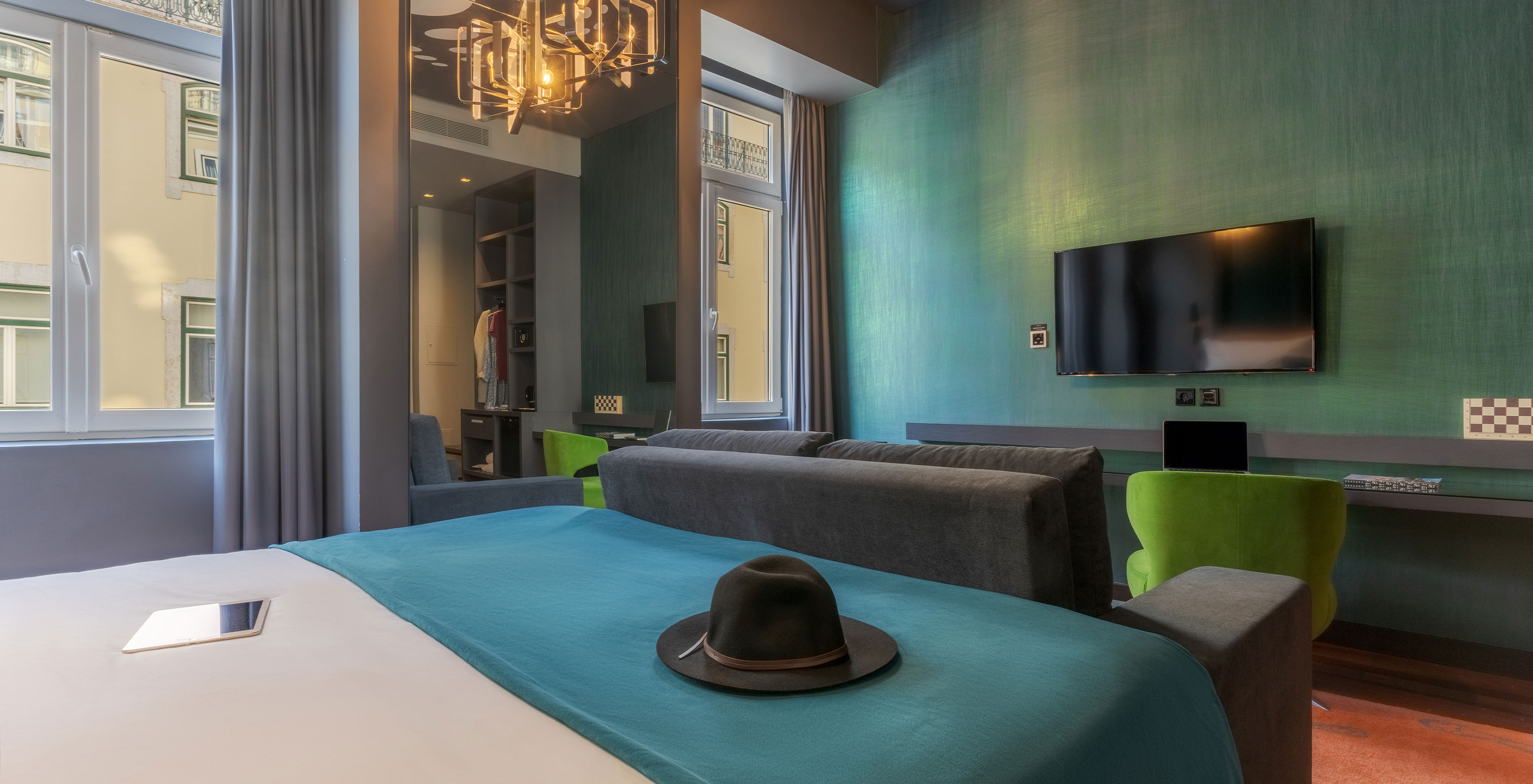 The CR7 Family Hat-Trick Room at Pestana CR7 Lisboa has a mirror, a sofa with television, and a bed