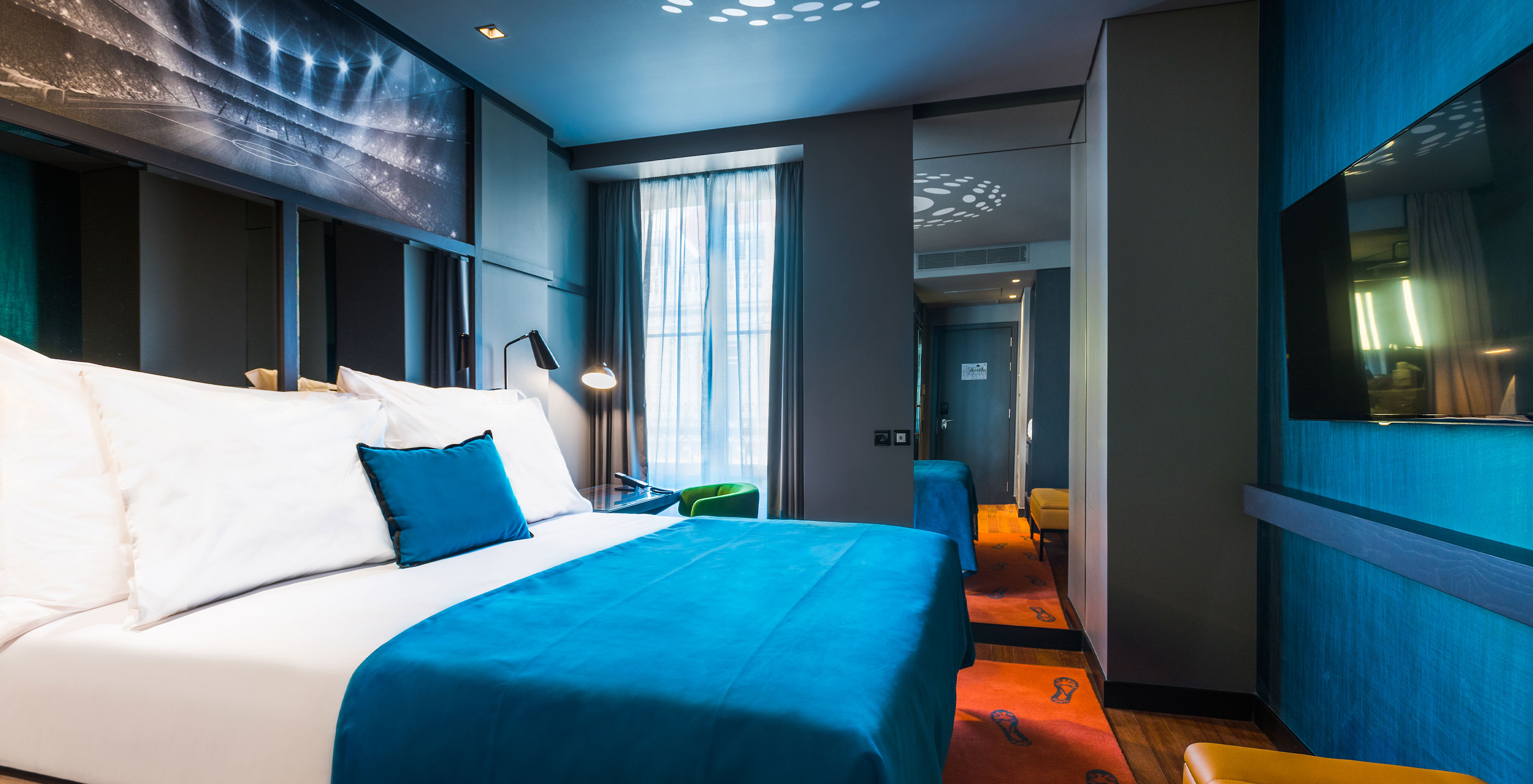 The CR7 Room at Pestana CR7 Lisboa includes a double bed, a mirror, and a desk