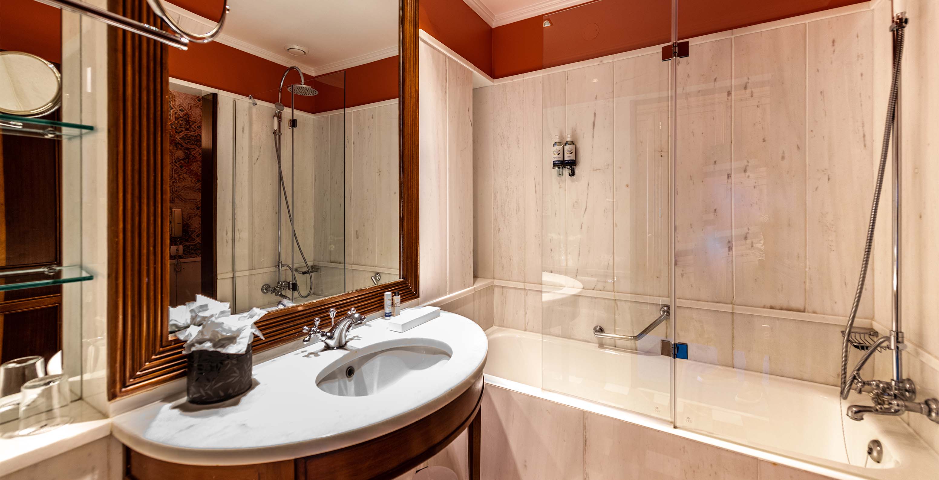 The Deluxe Garden room at Pestana Palace Lisbon features a bathroom with a bathtub, a marble and wood sink, and a mirror