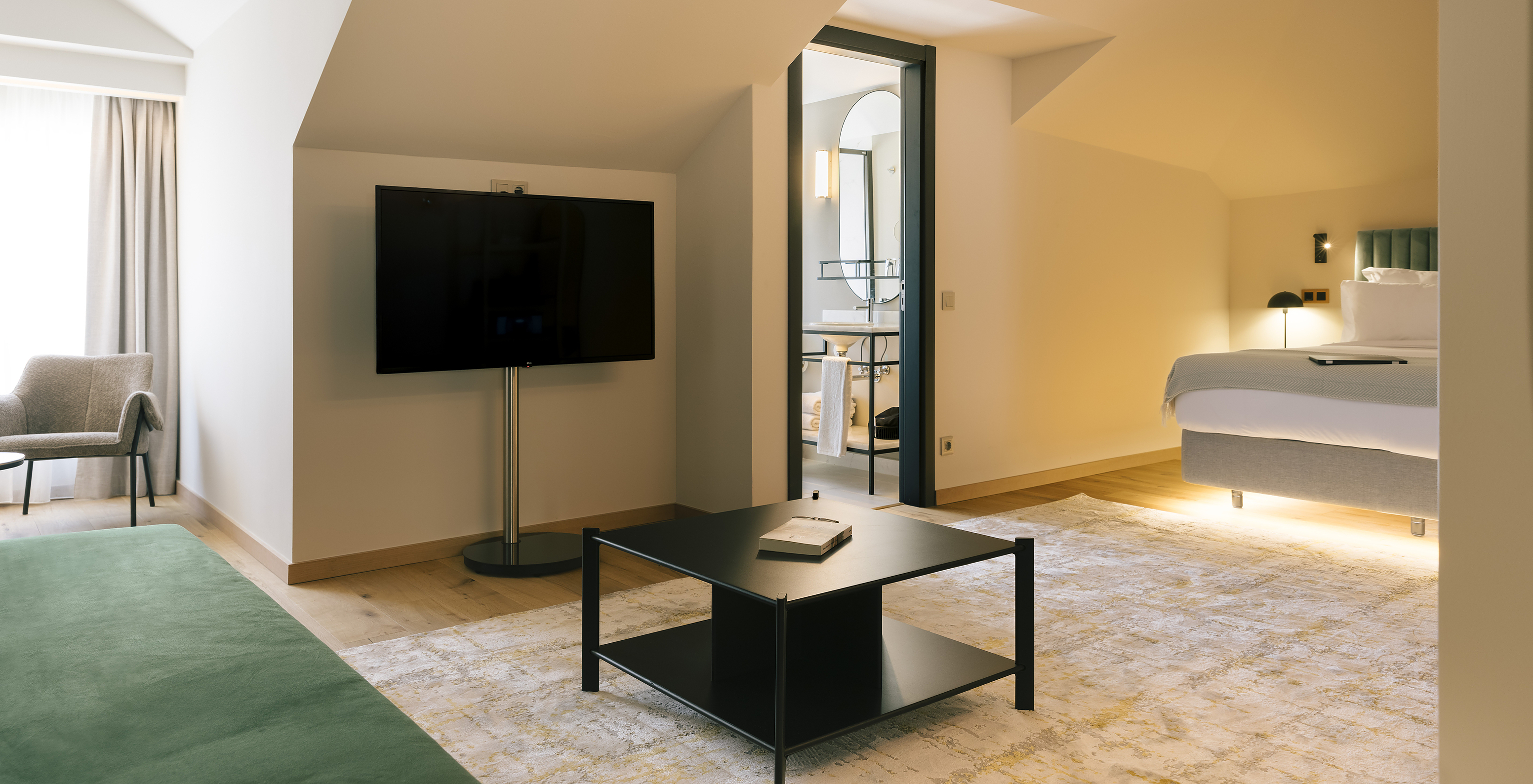 The Junior Suite of Pestana Rua Augusta Lisboa has a double bed, a television, a side table, and a chair