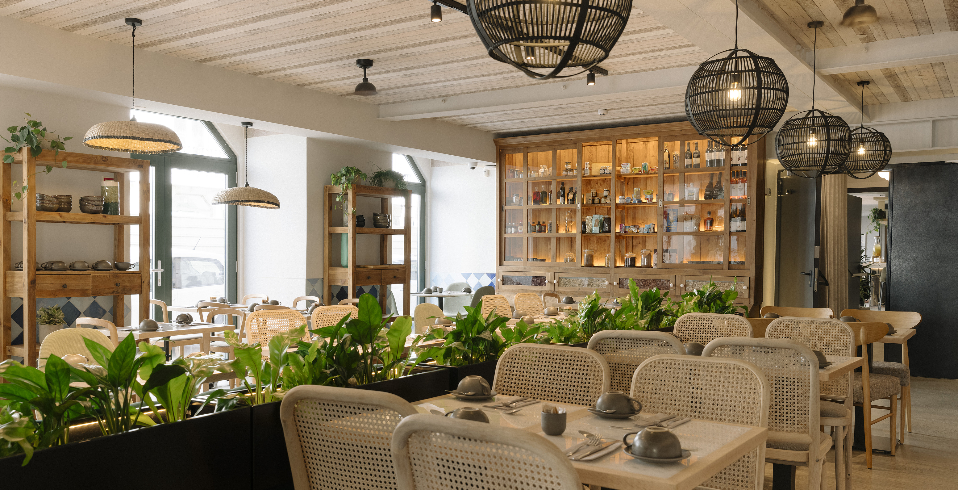 The Olive restaurant at the Hotel in downtown Lisbon features modern decor with plants and rattan chairs