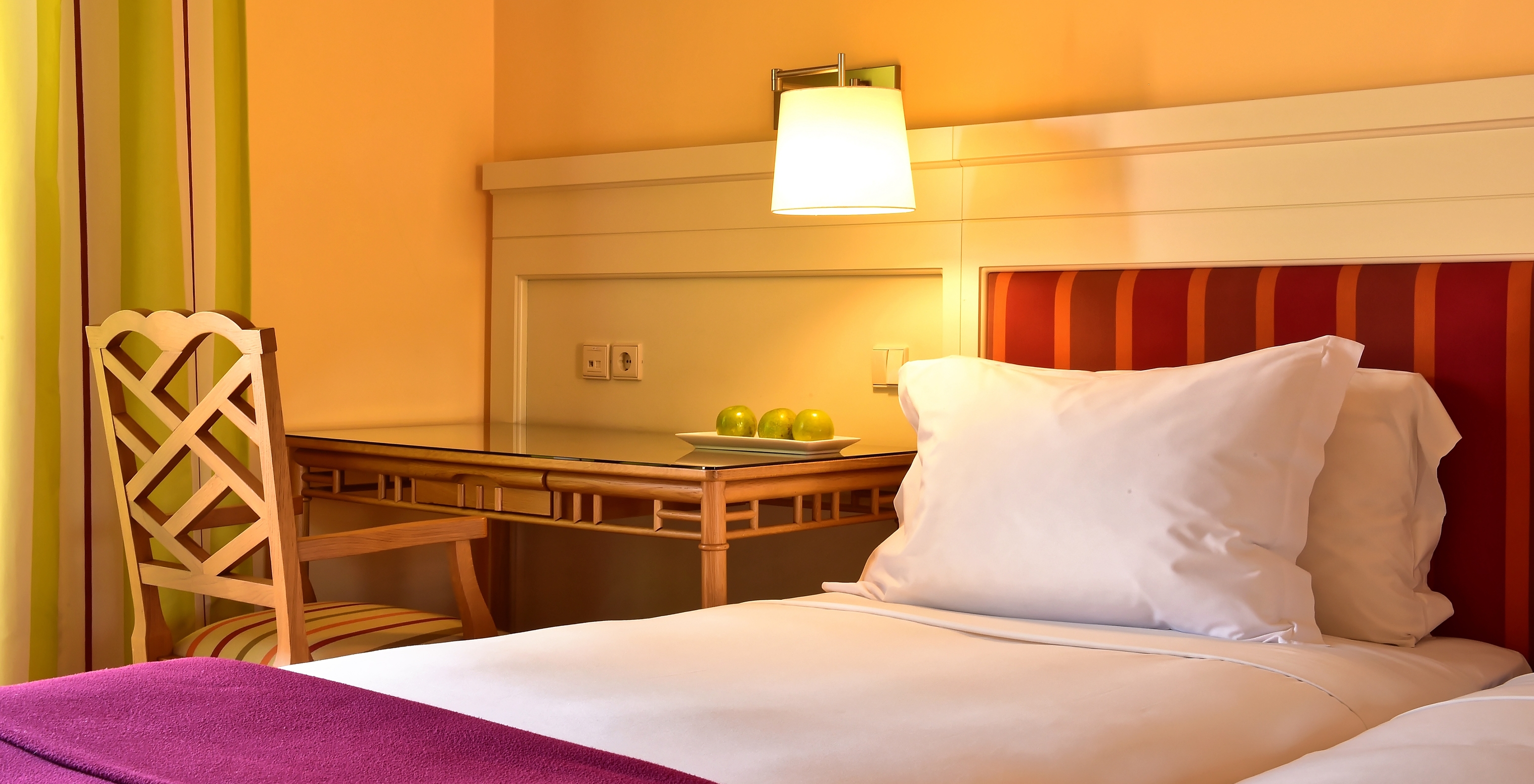 The Classic Double of Pestana Sintra Golf has a bed with white sheets and pillows, and a desk with a chair