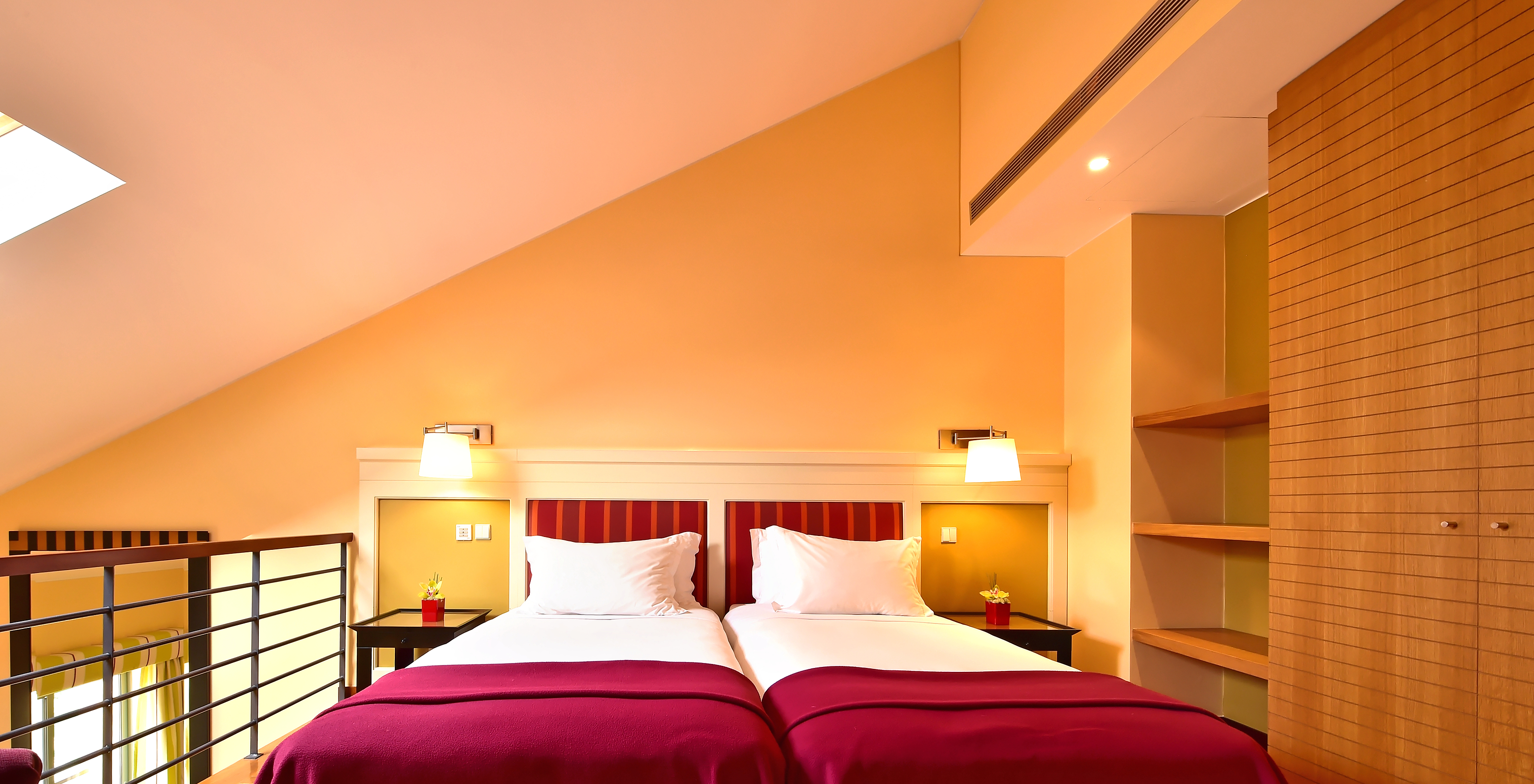 The Family Mezzanine Suite of Pestana Sintra Golf has a mezzanine with two beds, bedside table, wardrobe, and shelves