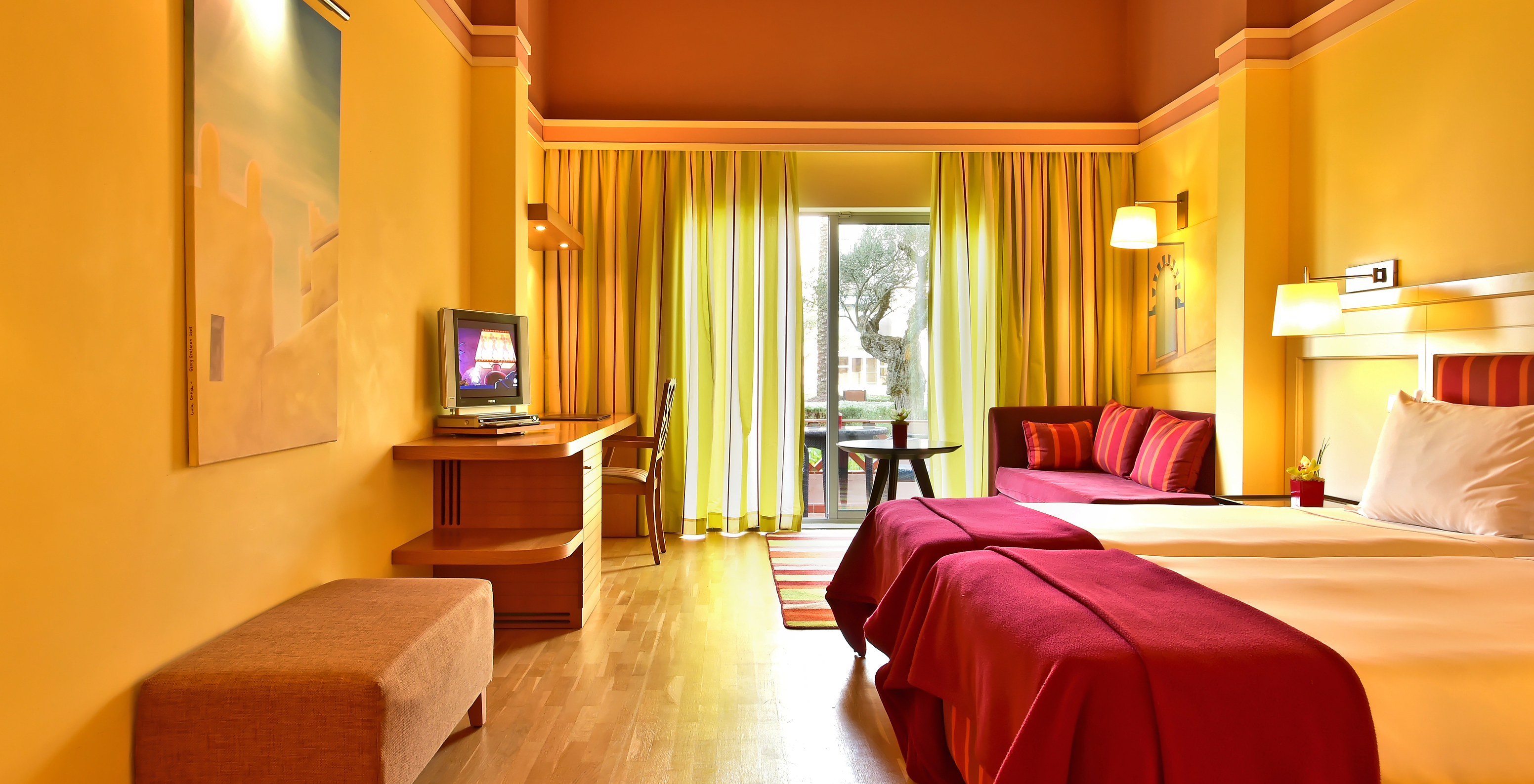 The Superior Double of Pestana Sintra Golf has two beds, a television, a sofa, and a window with curtains and garden view