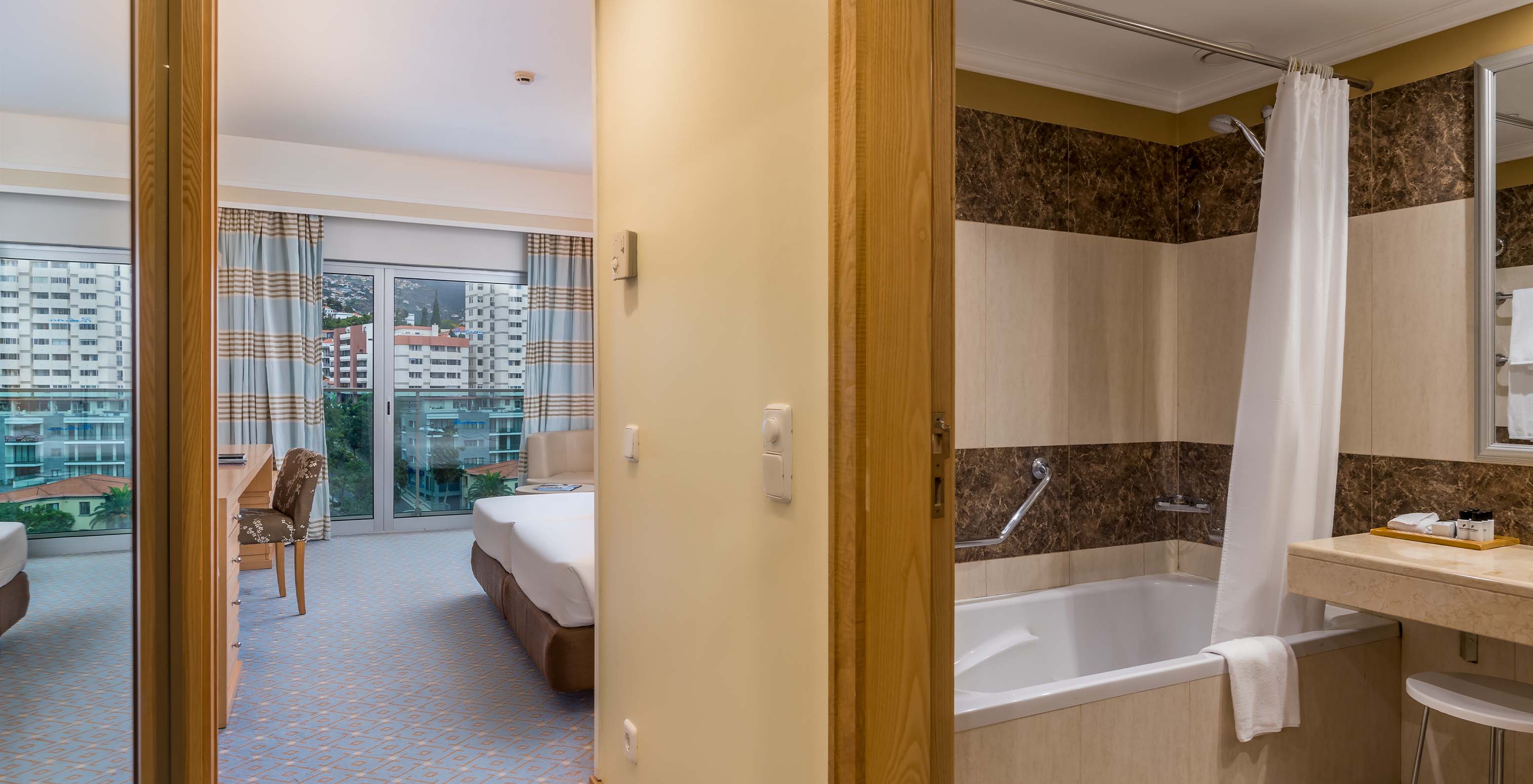 The Classic Double Room with City View at Pestana Carlton Madeira has a bathroom, large window, and a double bed