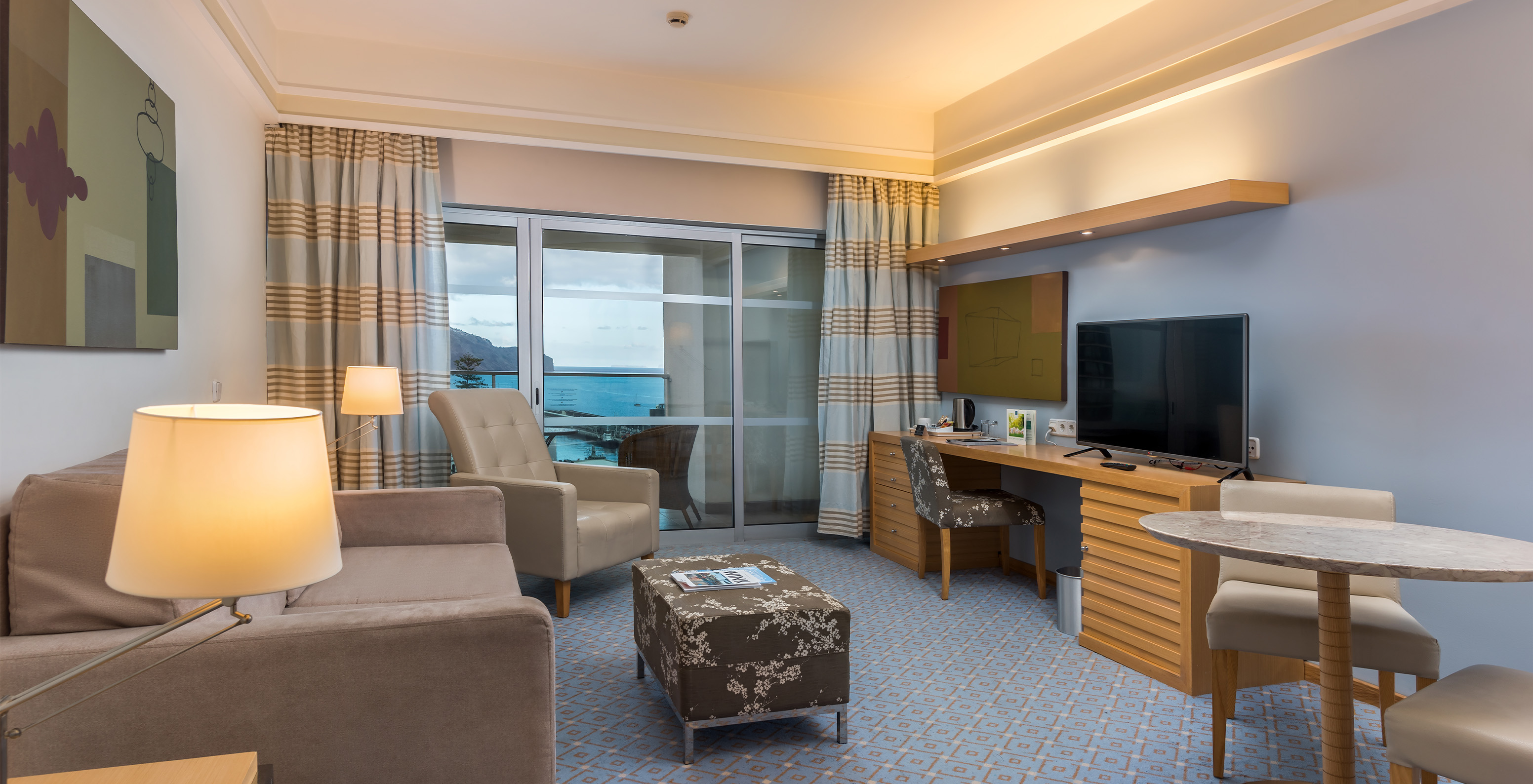 The Superior Classic Double Room with Sea View at Pestana Carlton Madeira has a seating area with a sofa, TV, and balcony