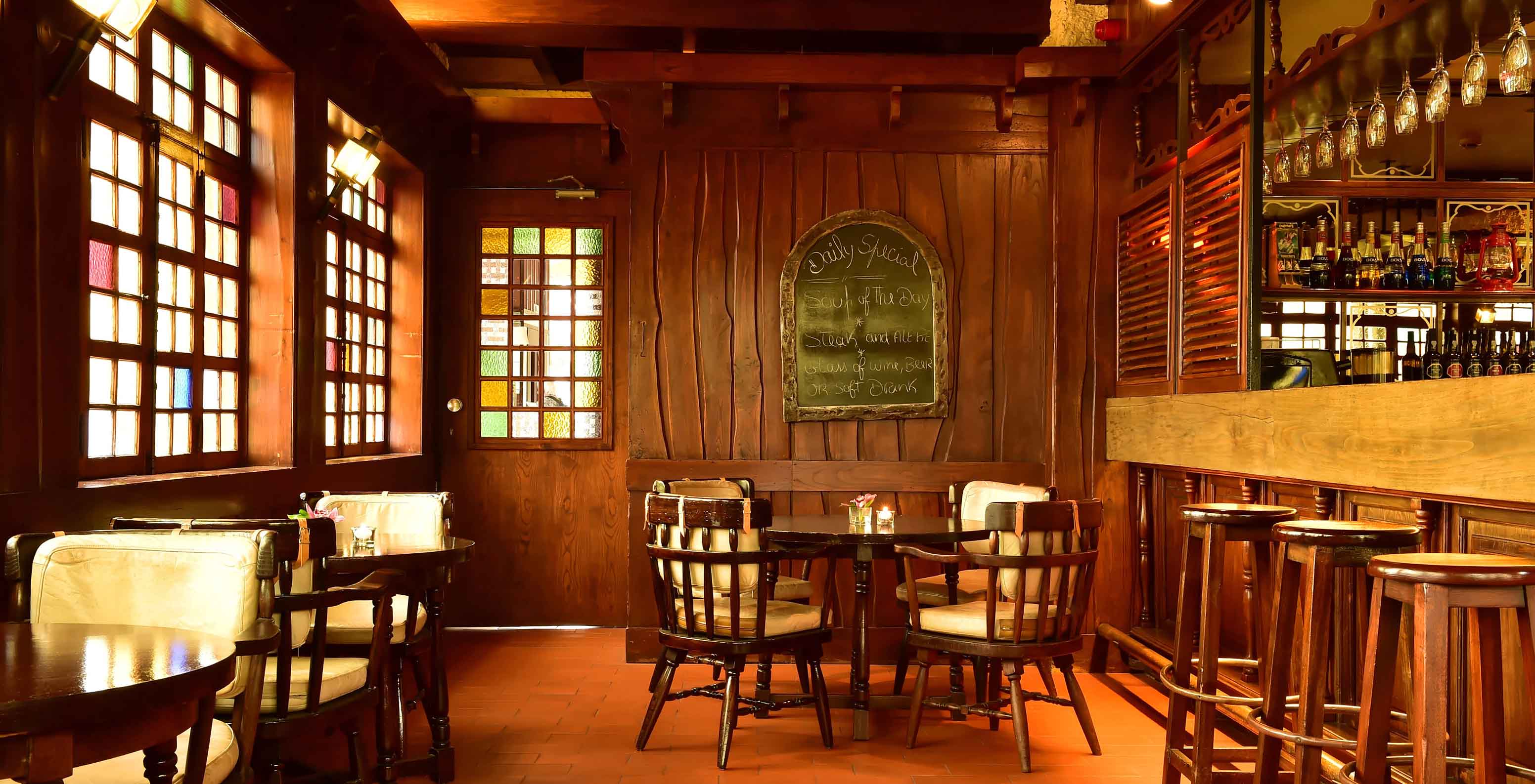 The Pub bar, at the 5-Star Hotel in Madeira, has a counter surrounded by high stools and various drinks