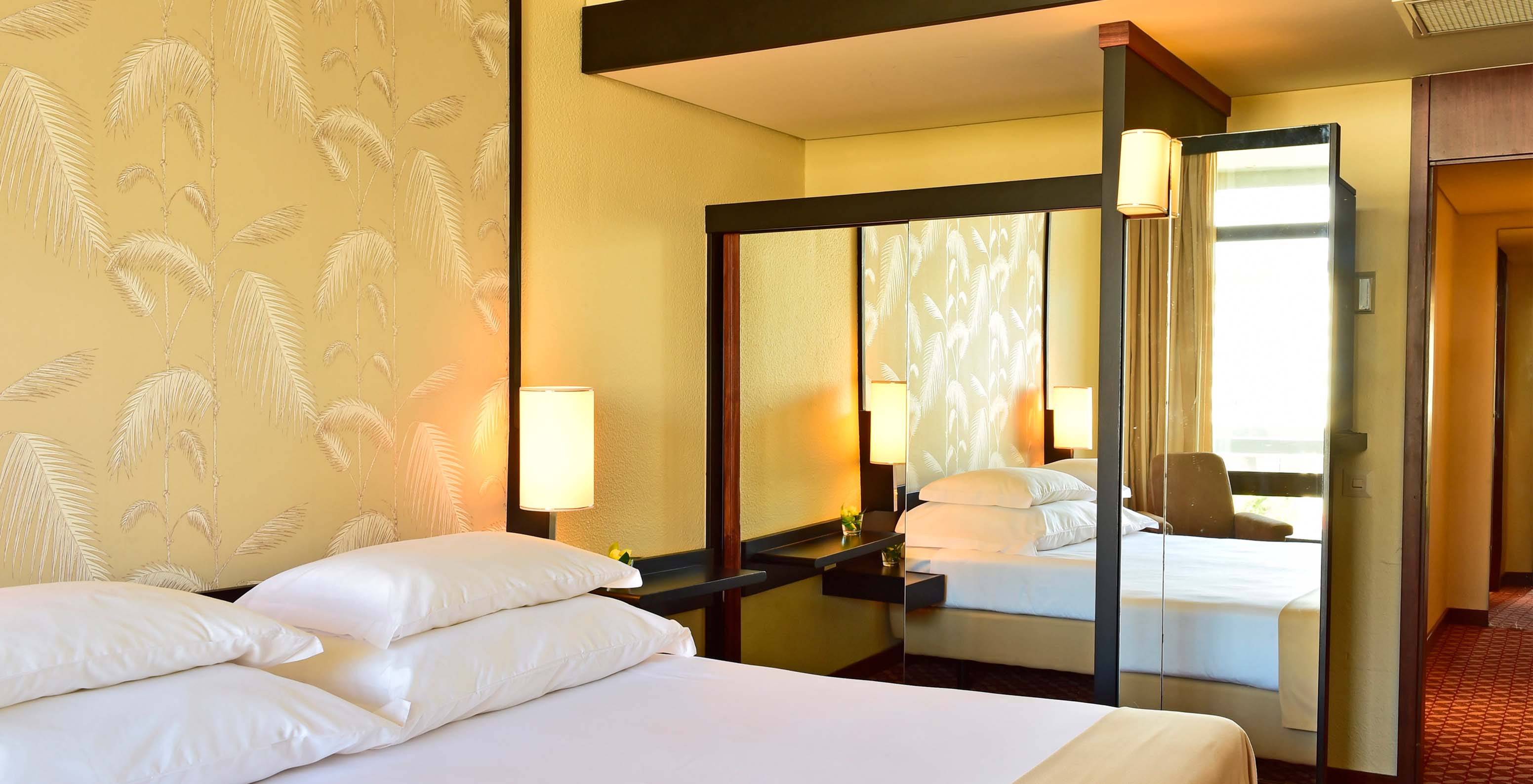 The Classic Land View room at Pestana Casino Park has a mirrored wardrobe next to the double bed