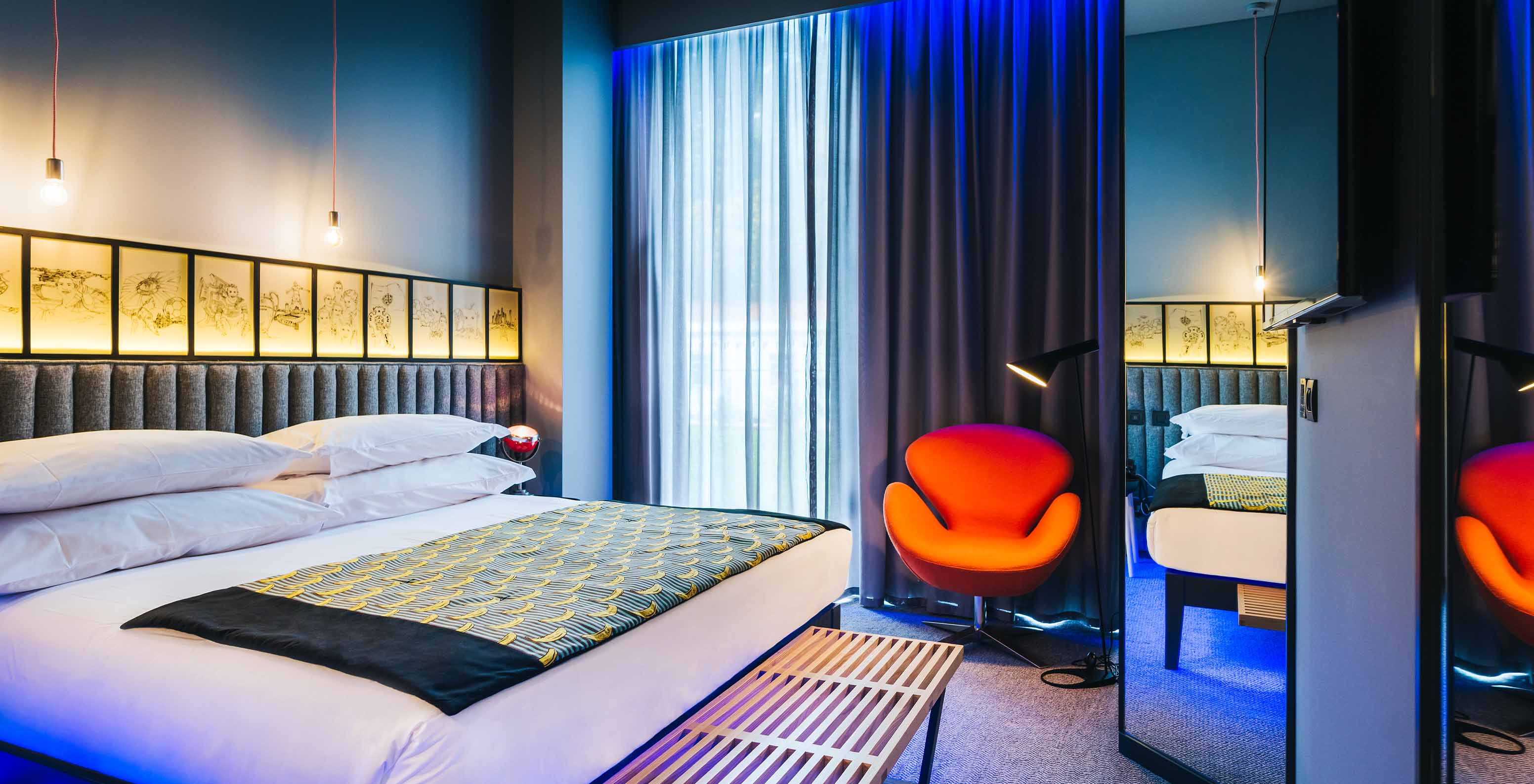 The CR7 Room at Pestana CR7 Funchal has spacious decor with a double bed, a bench, and a comfortable chair