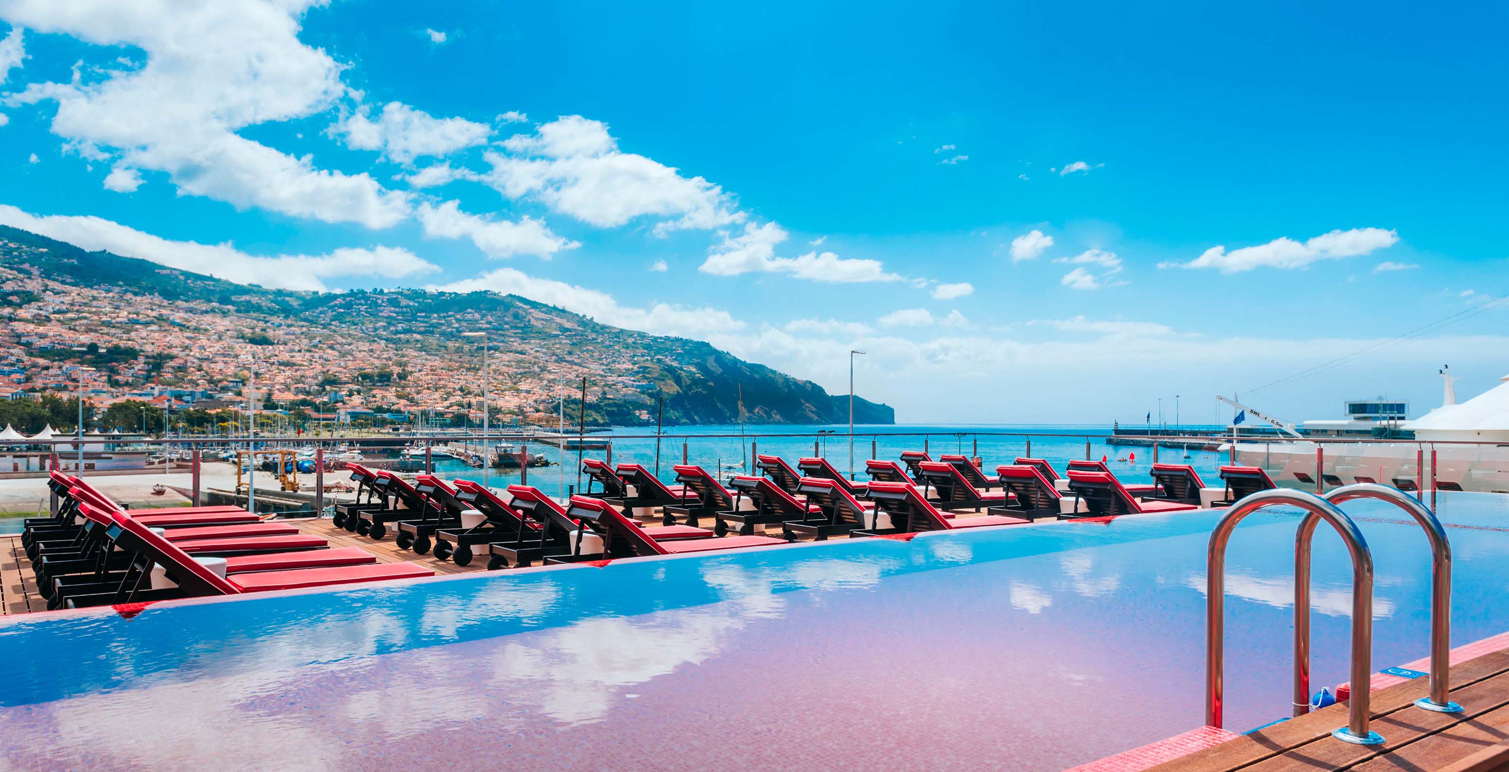 View of the pink outdoor pool to the sea and Funchal at the hotel of the Cristiano Ronaldo brand