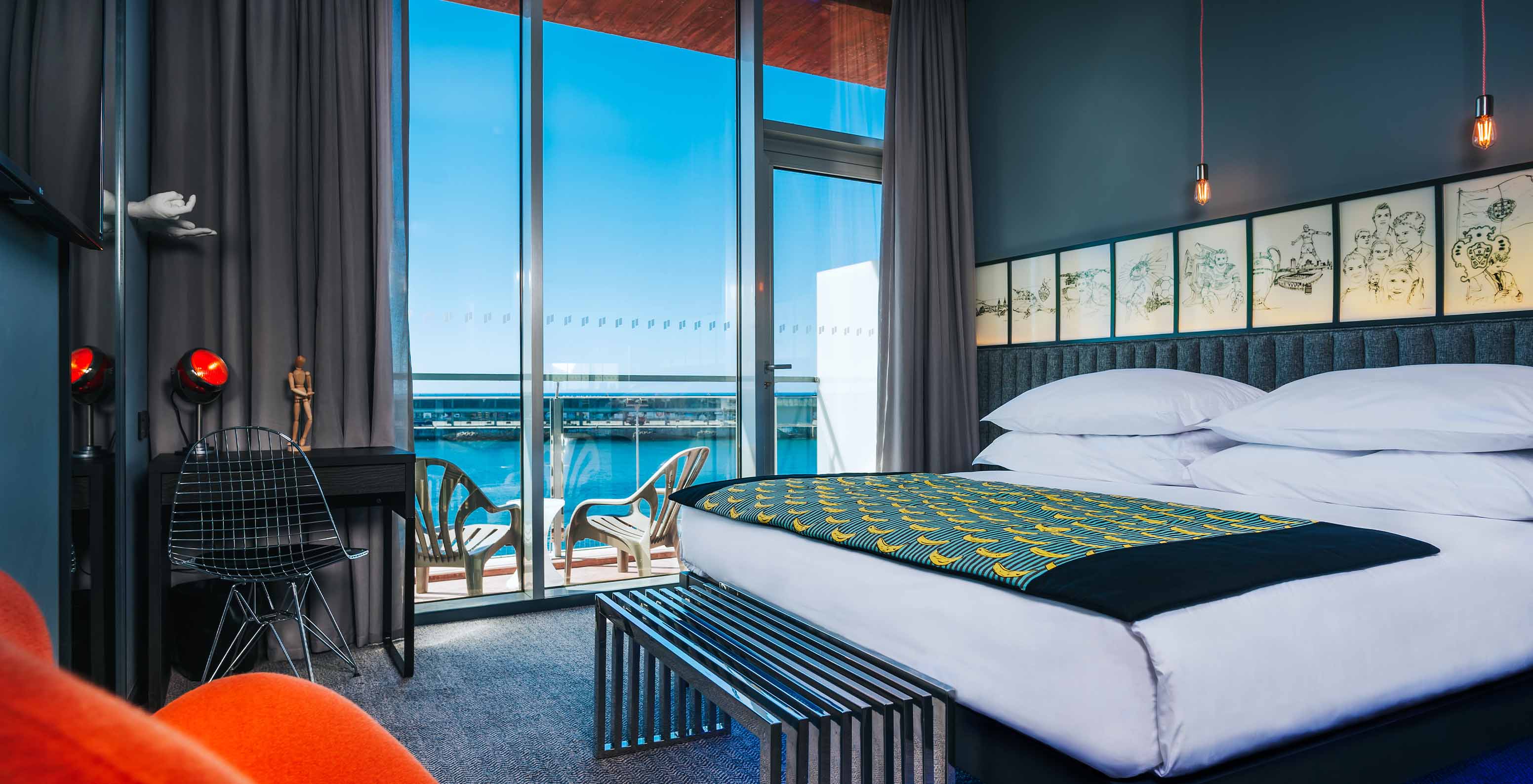 The CR Superior Room at Pestana CR7 Funchal features a balcony beside the double bed, with two chairs and sea view