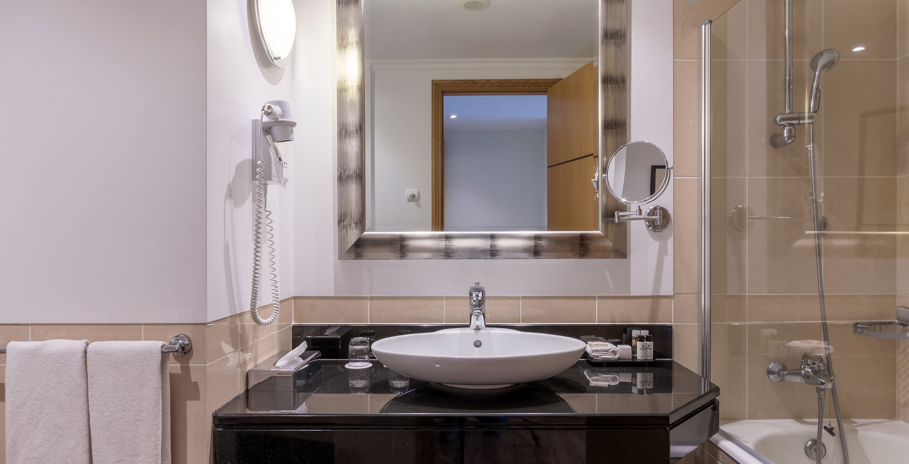 The Classic Inland View Room at Pestana Grand has a bathroom with a sink, bathtub with shower and towel