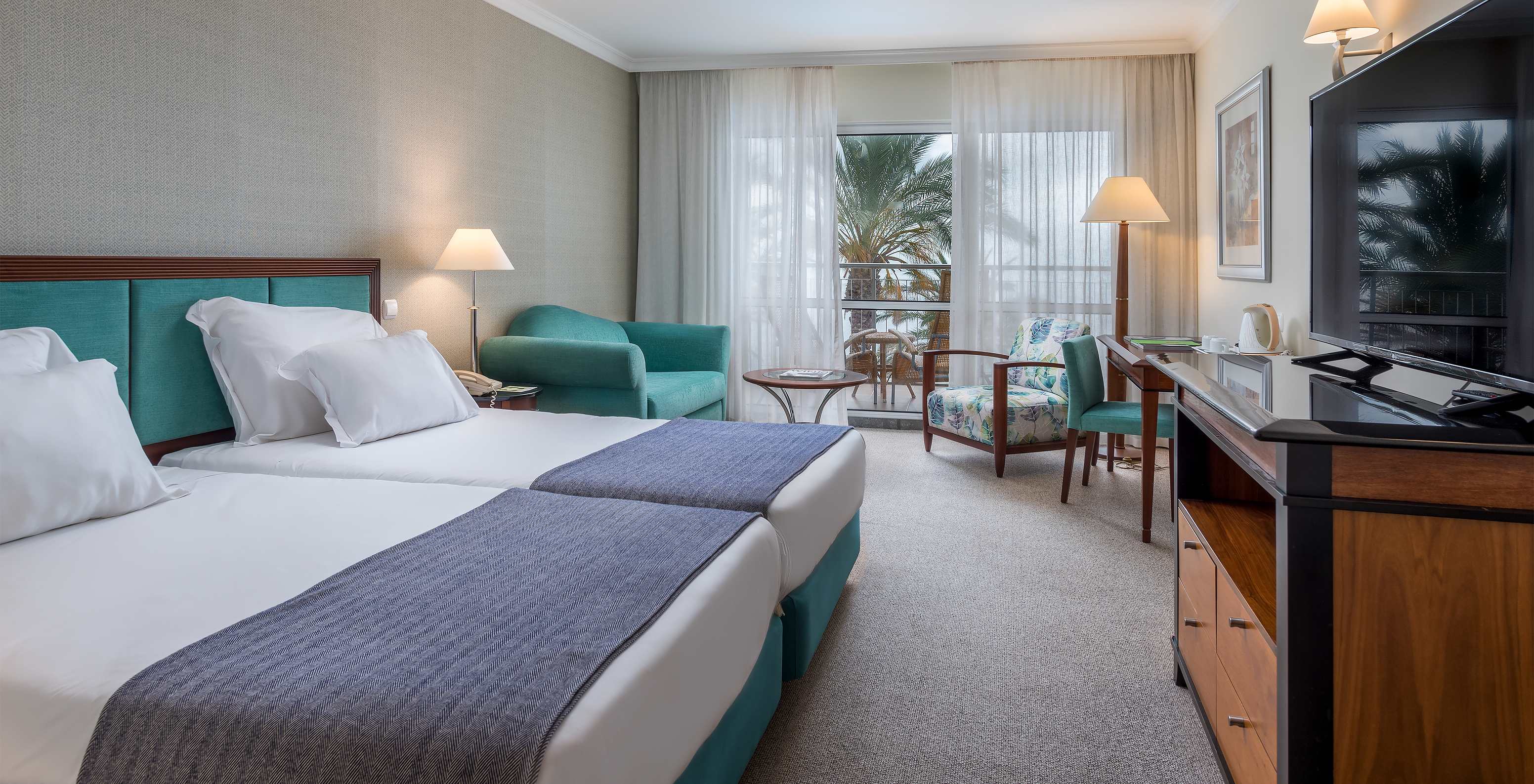 The Classic Inland View Room at Pestana Grand has two single beds, TV and an armchair