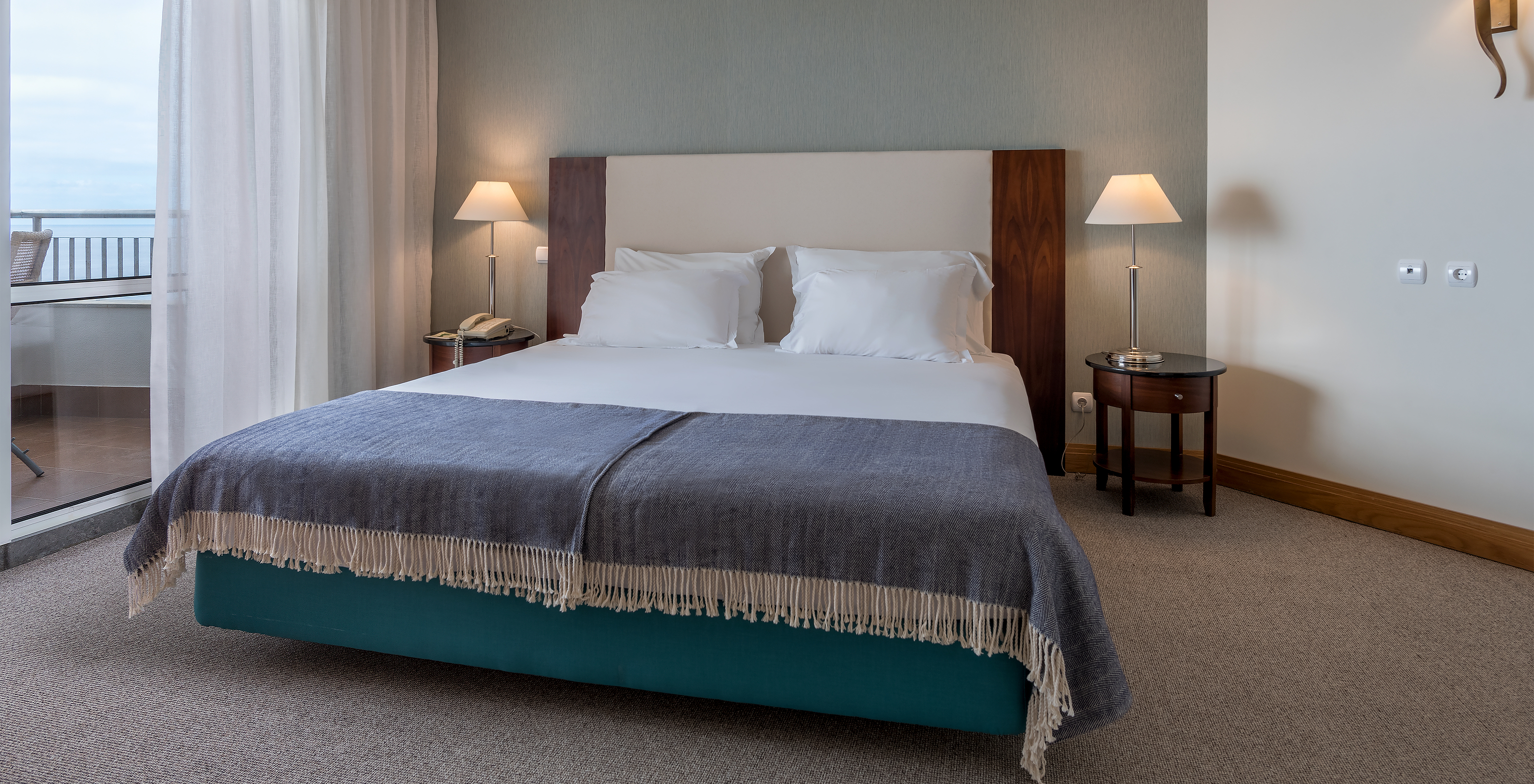 The Twin Superior Sea View Room at Pestana Grand has a double bed with bedside table and lamps