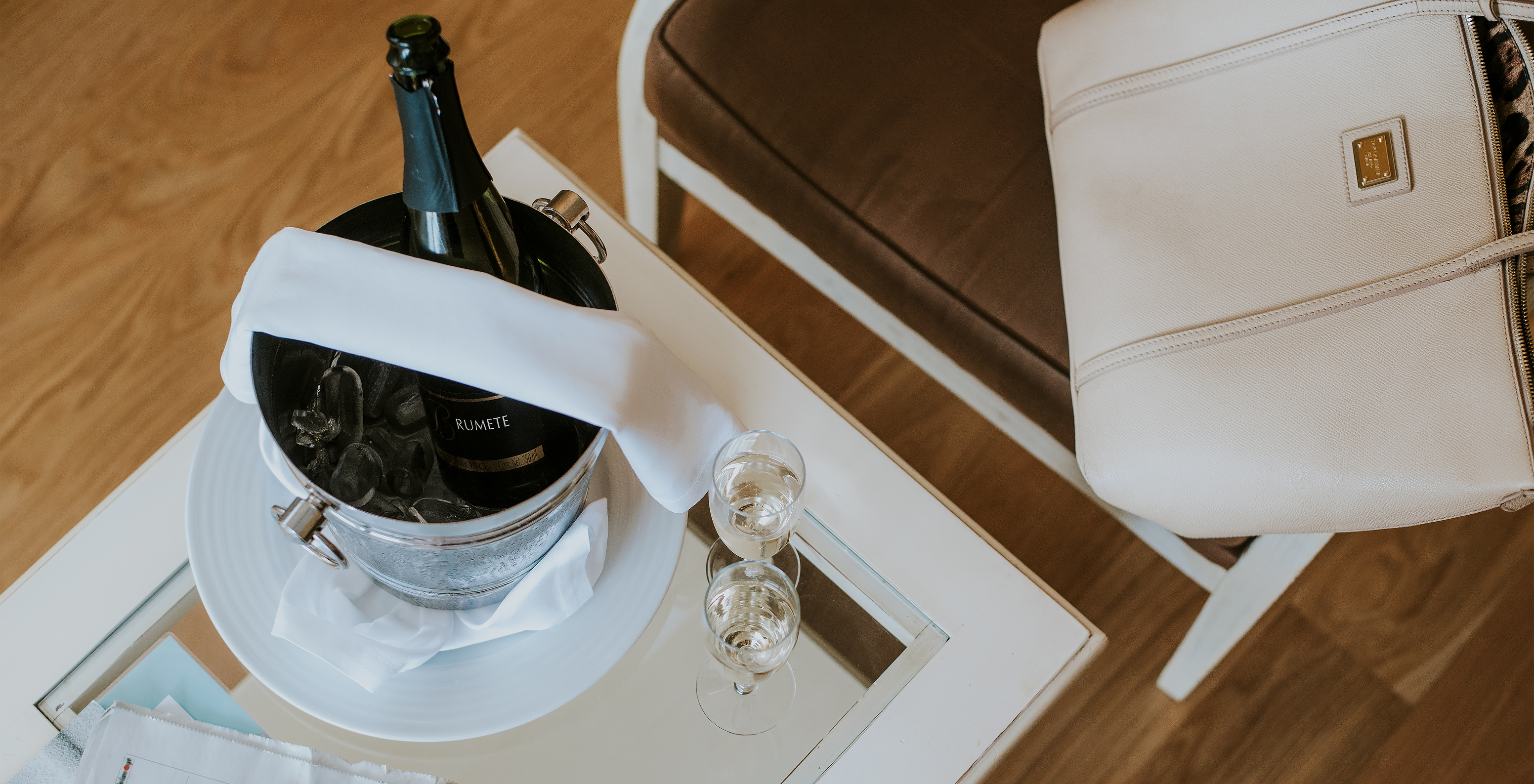 The T2 Apartment at Pestana Madeira Beach Club has a table with champagne on ice, newspapers and a chair