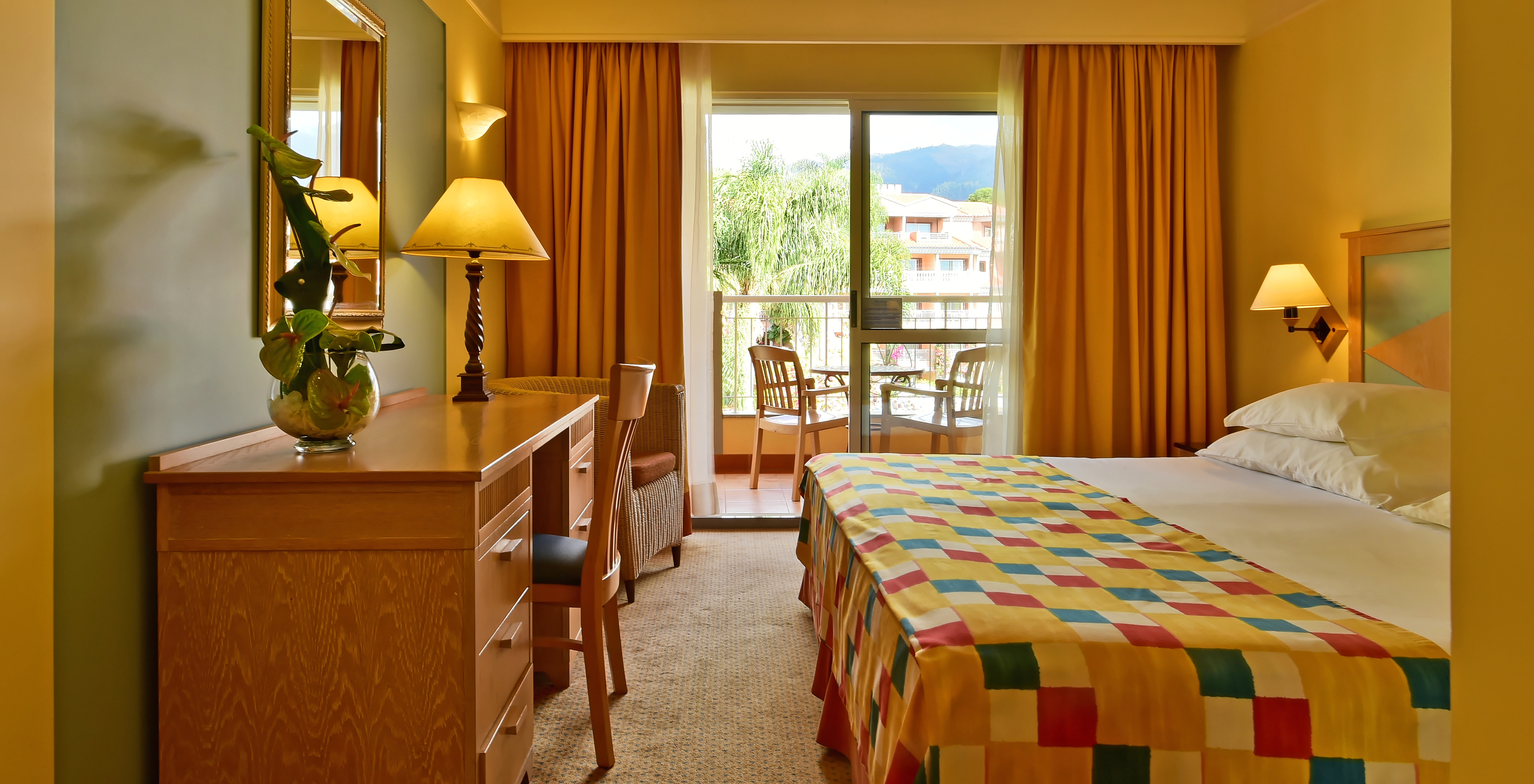 The Superior Room at Pestana Miramar has a double bed, a desk and a balcony with table and chairs