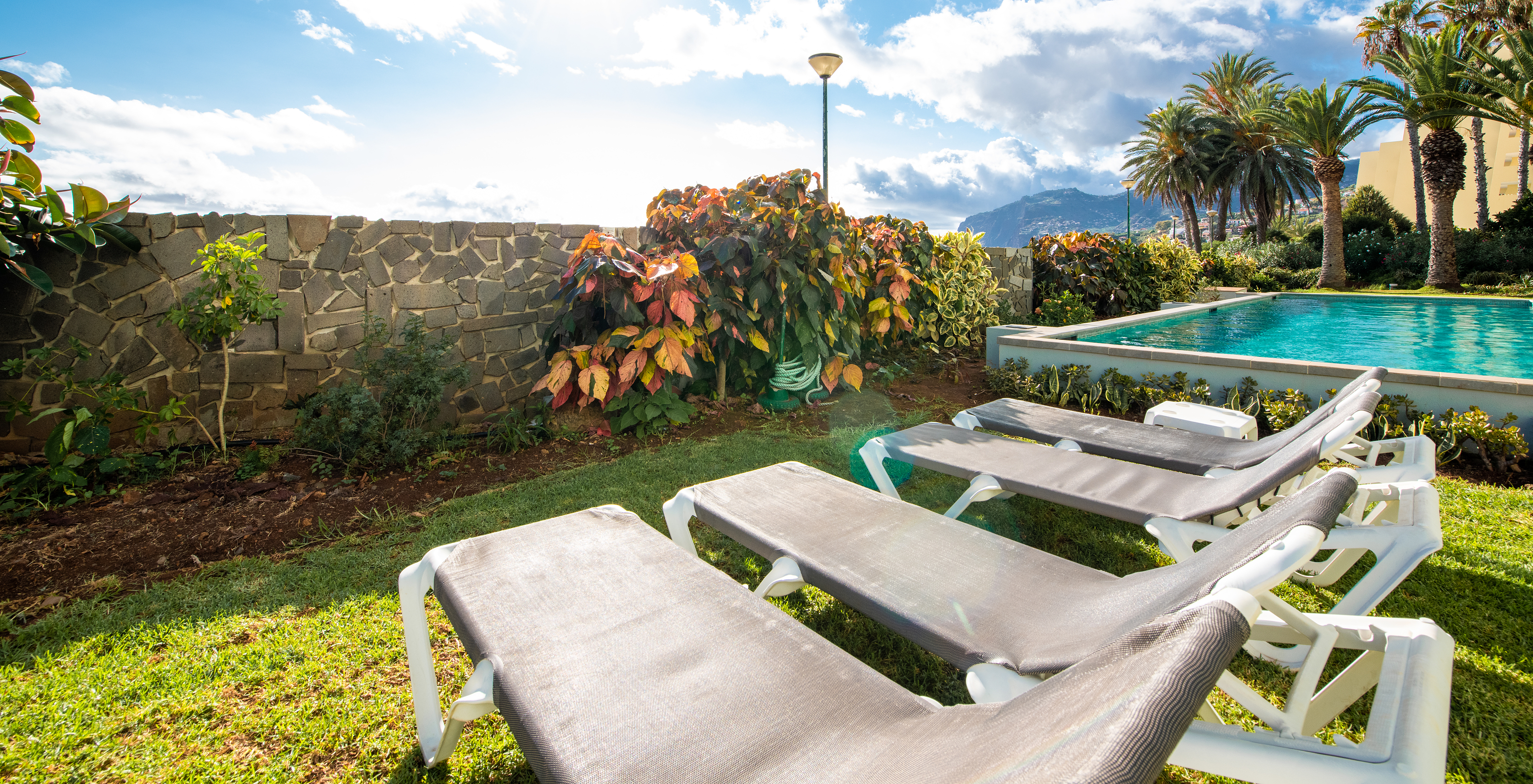 Loungers at the pool of Pestana Ocean Bay All Inclusive, an all-inclusive hotel by the sea with pool