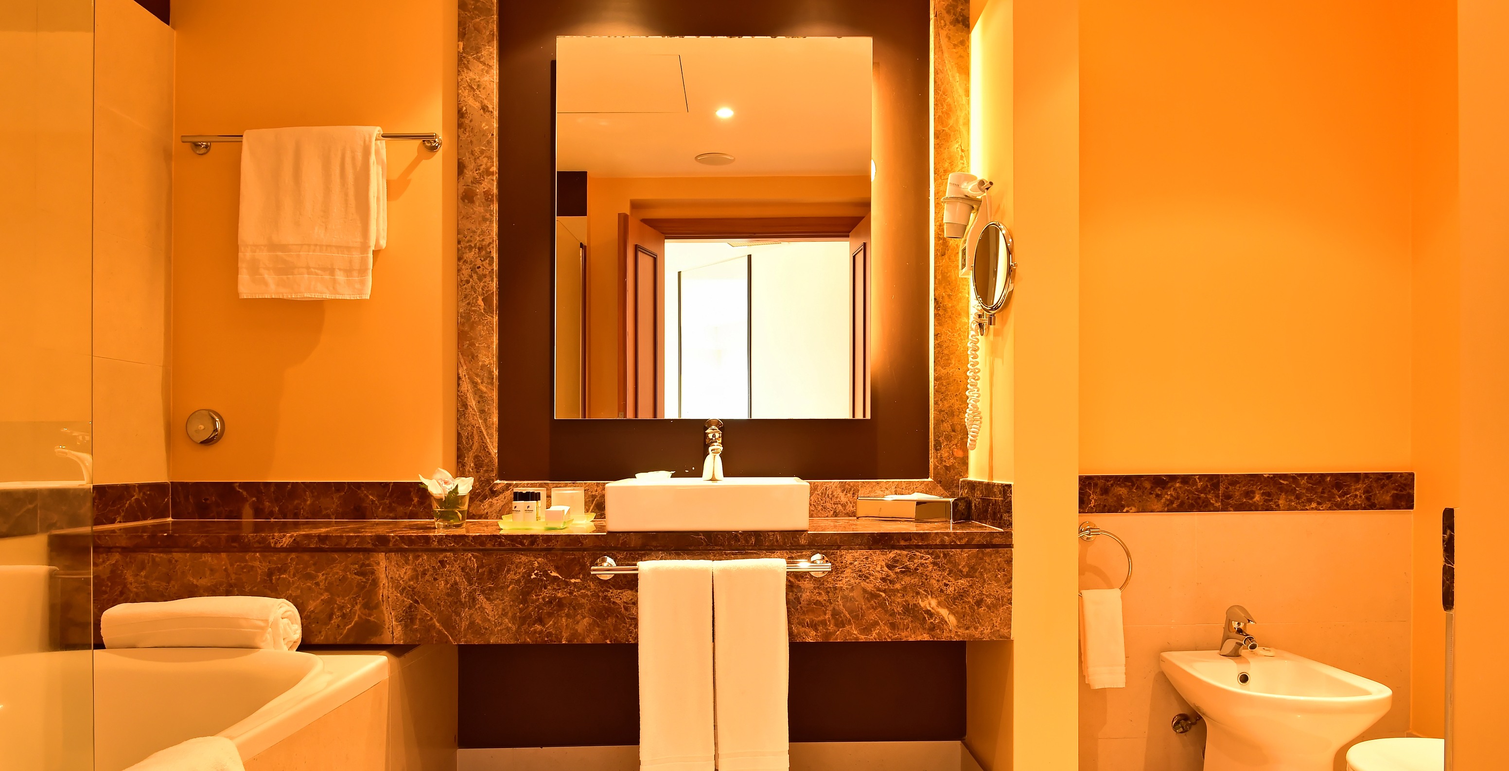 The Junior Suite of Pestana Promenade has a bathroom with bathtub, sink, and a square mirror