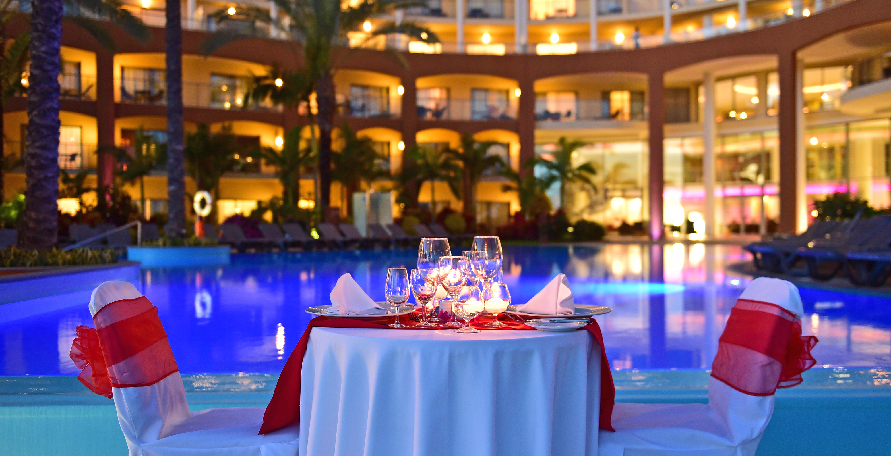 Pestana Promenade, a hotel in Madeira near the beach and Lido, has a table by the pool for romantic dinners