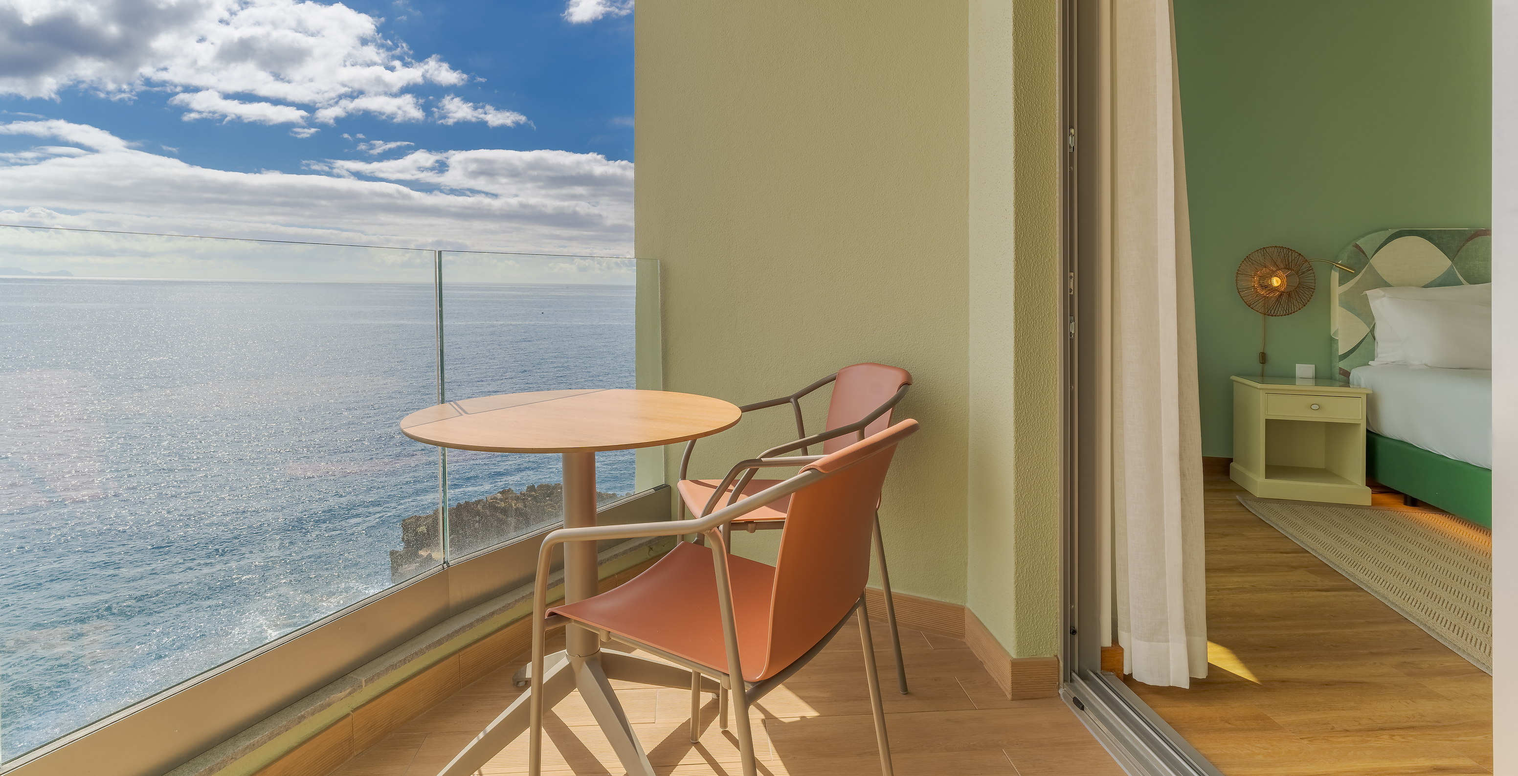 The Classic Sea View room at Pestana Vila Lido Madeira features a balcony with a table, chairs, and sea view