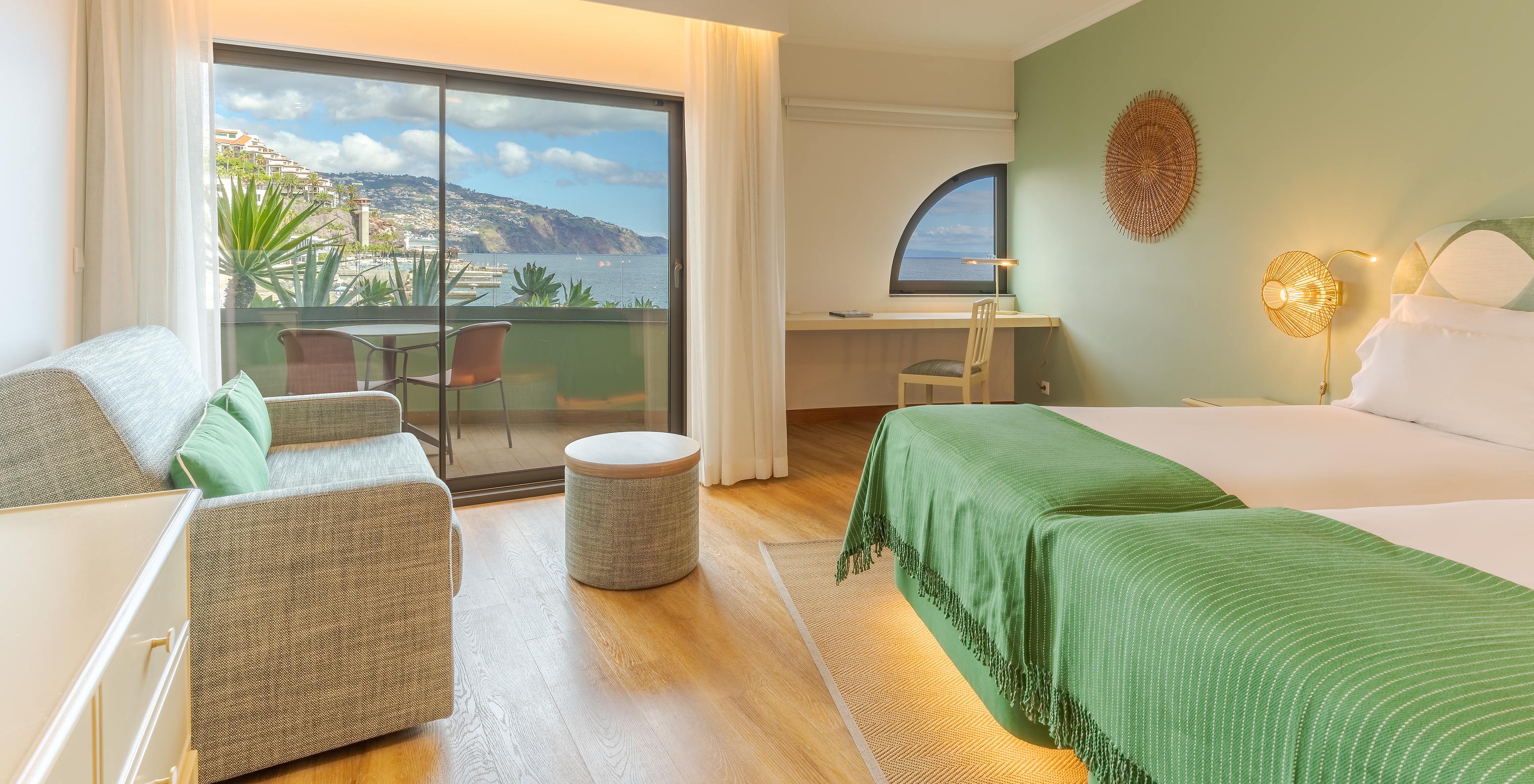 The Classic Lateral Sea View room at Pestana Vila Lido Madeira features a small window at the desk and a window with balcony