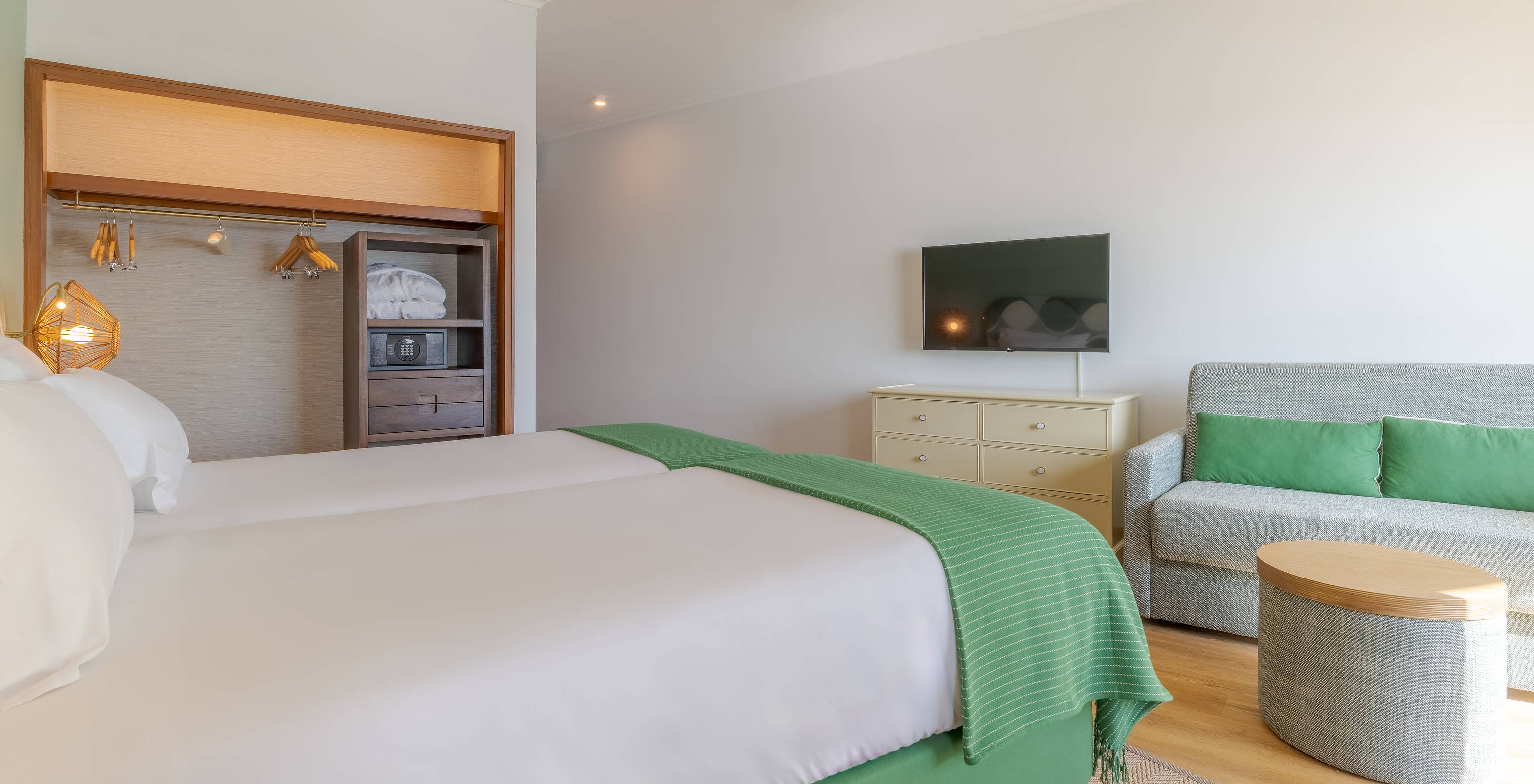 The Classic Sea View room at Pestana Vila Lido Madeira features a wall-mounted television, a wardrobe with safe, and two beds