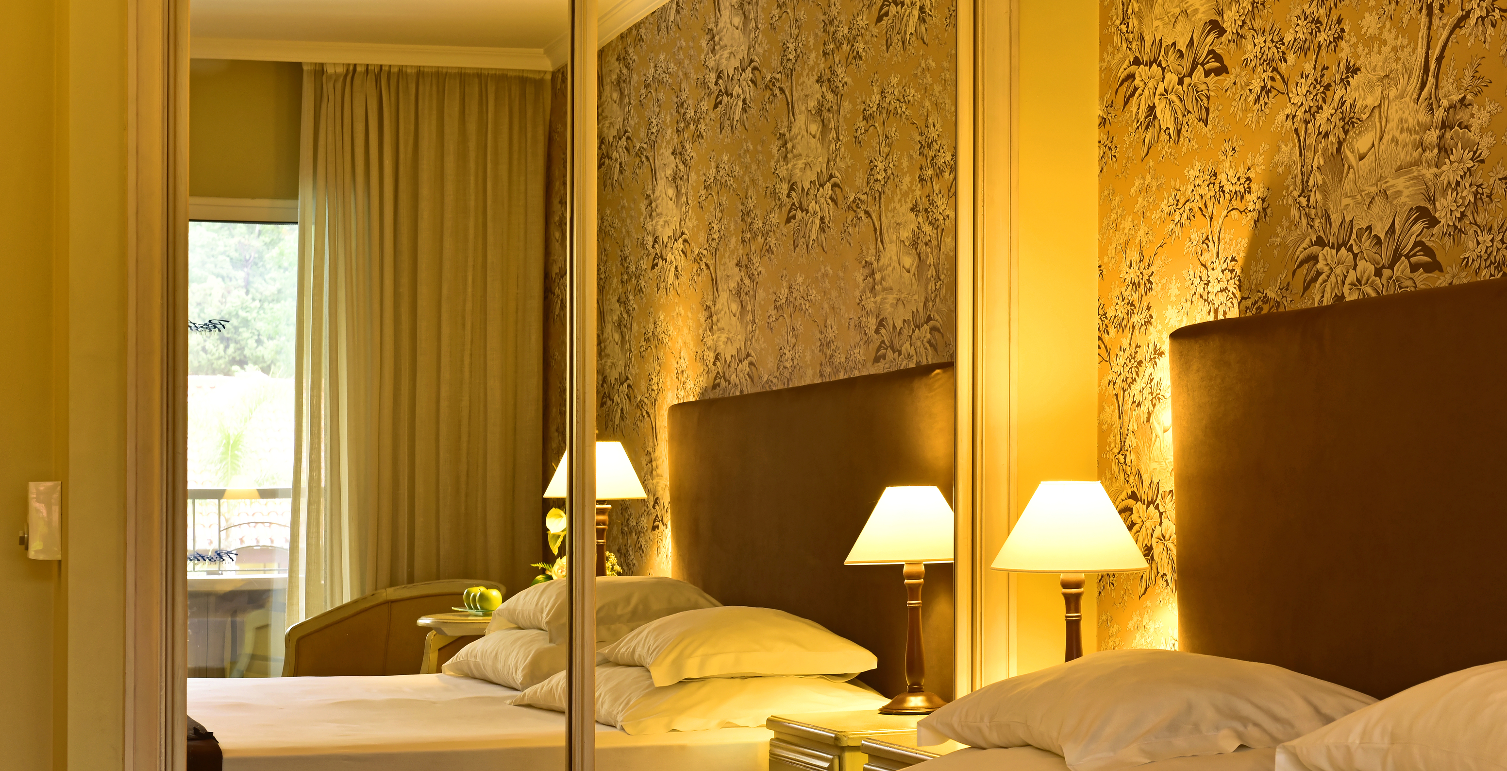 The Suite with Jacuzzi at Pestana Village has a double bed with headboard and brown bedspread, and wardrobe with mirror