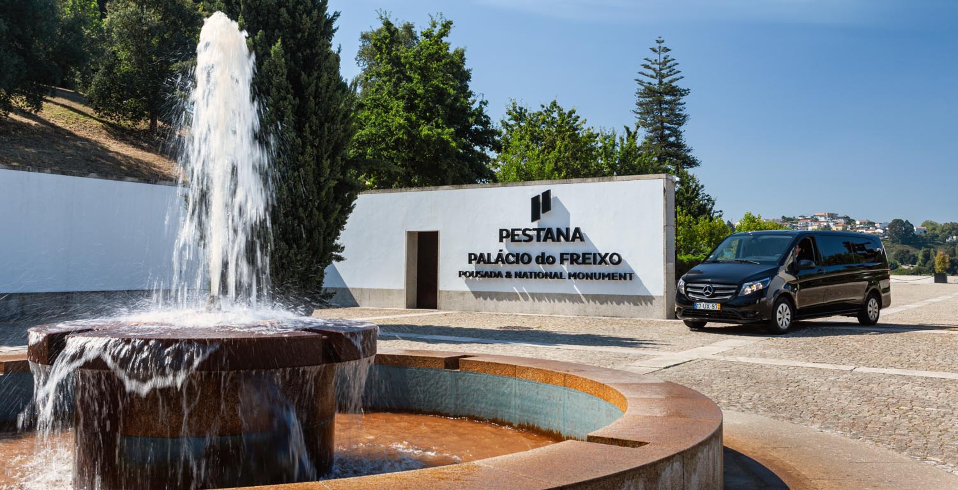 Fountain at Pestana Palácio do Freixo with a sign saying "Pestana Palácio do Freixo, Pousada & National Monument"