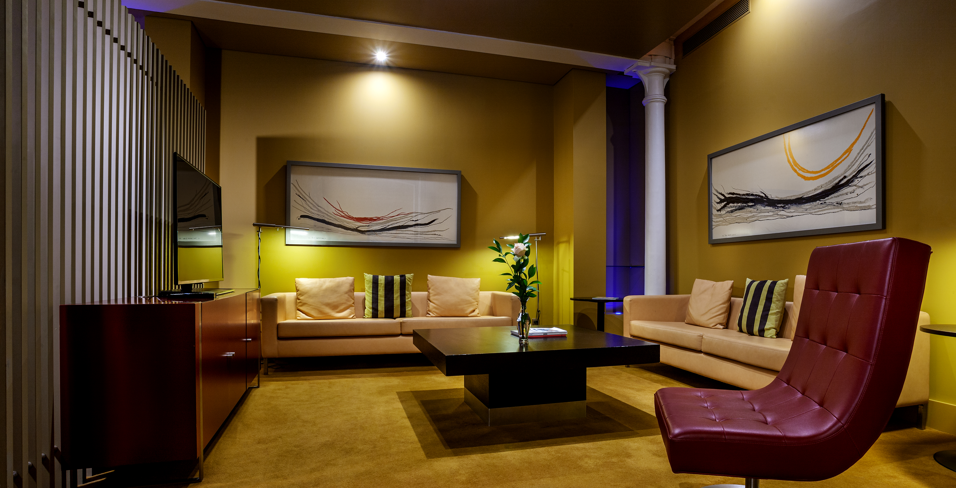 The Balcony Suite of Pestana Palácio do Freixo has a living room with two sofas, a center table, a TV and two paintings