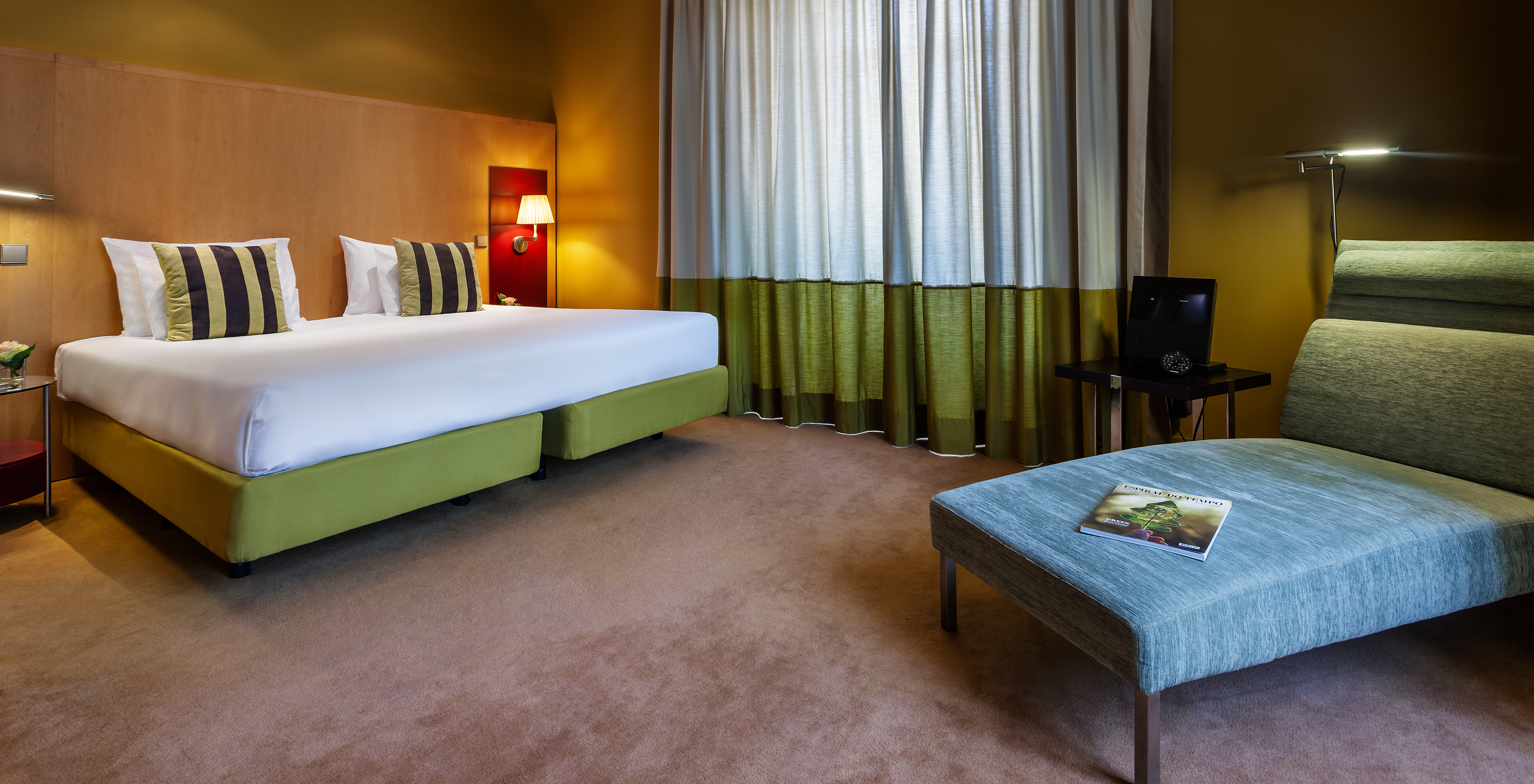 The Standard Suite of Pestana Palácio do Freixo has a double bed, a comfortable armchair and a window with curtains