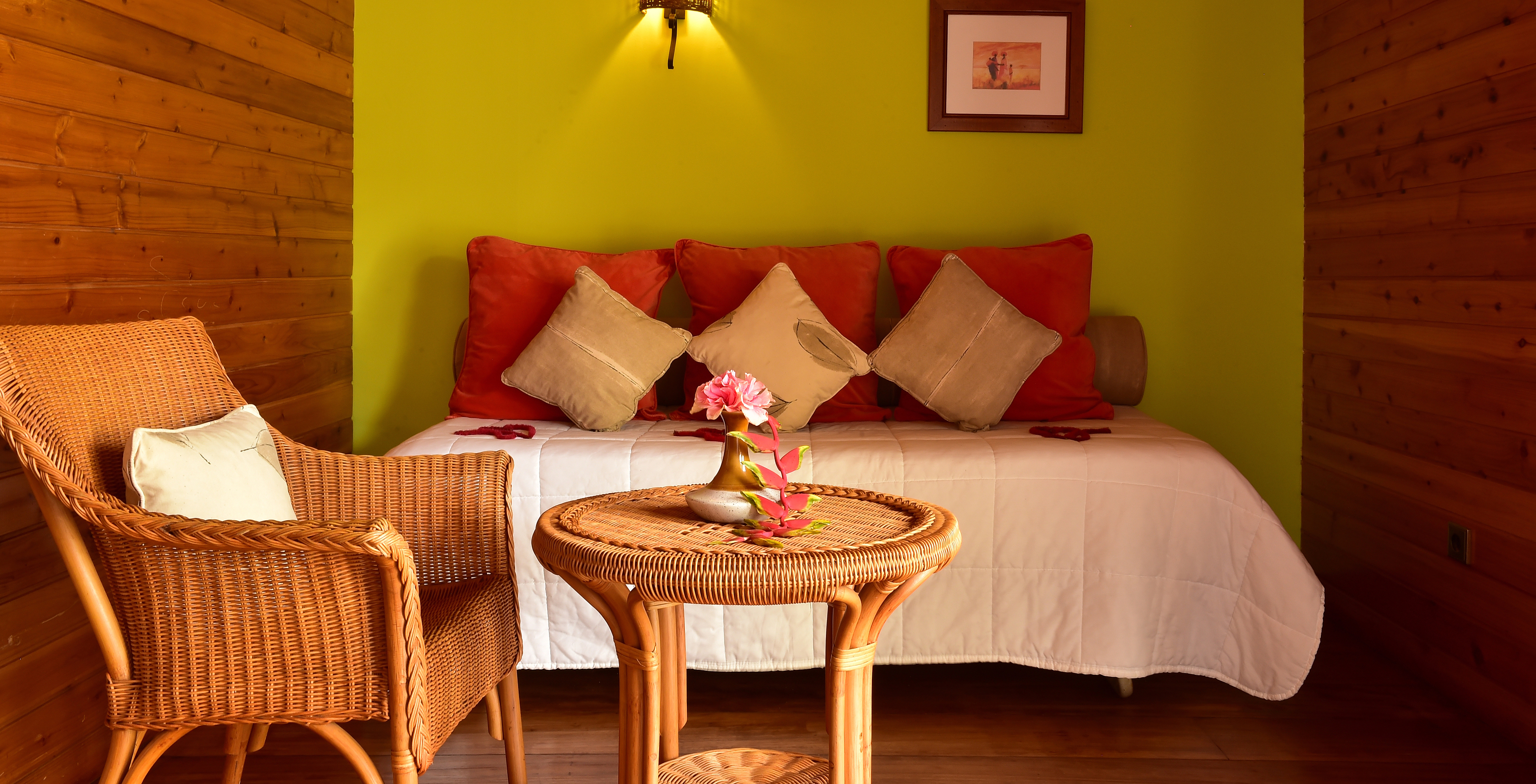 The Standard Suite at Pestana Equador Ilheu das Rolas features a green wall, a bed, a table, and a rattan chair