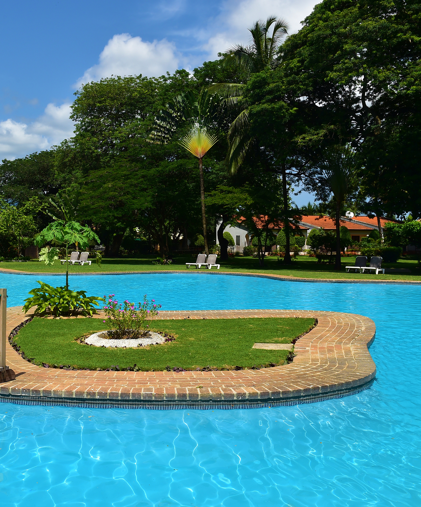 Outdoor pool at the hotel with a pool, facing the beach, resembling a natural lake with crystal clear deep blue water