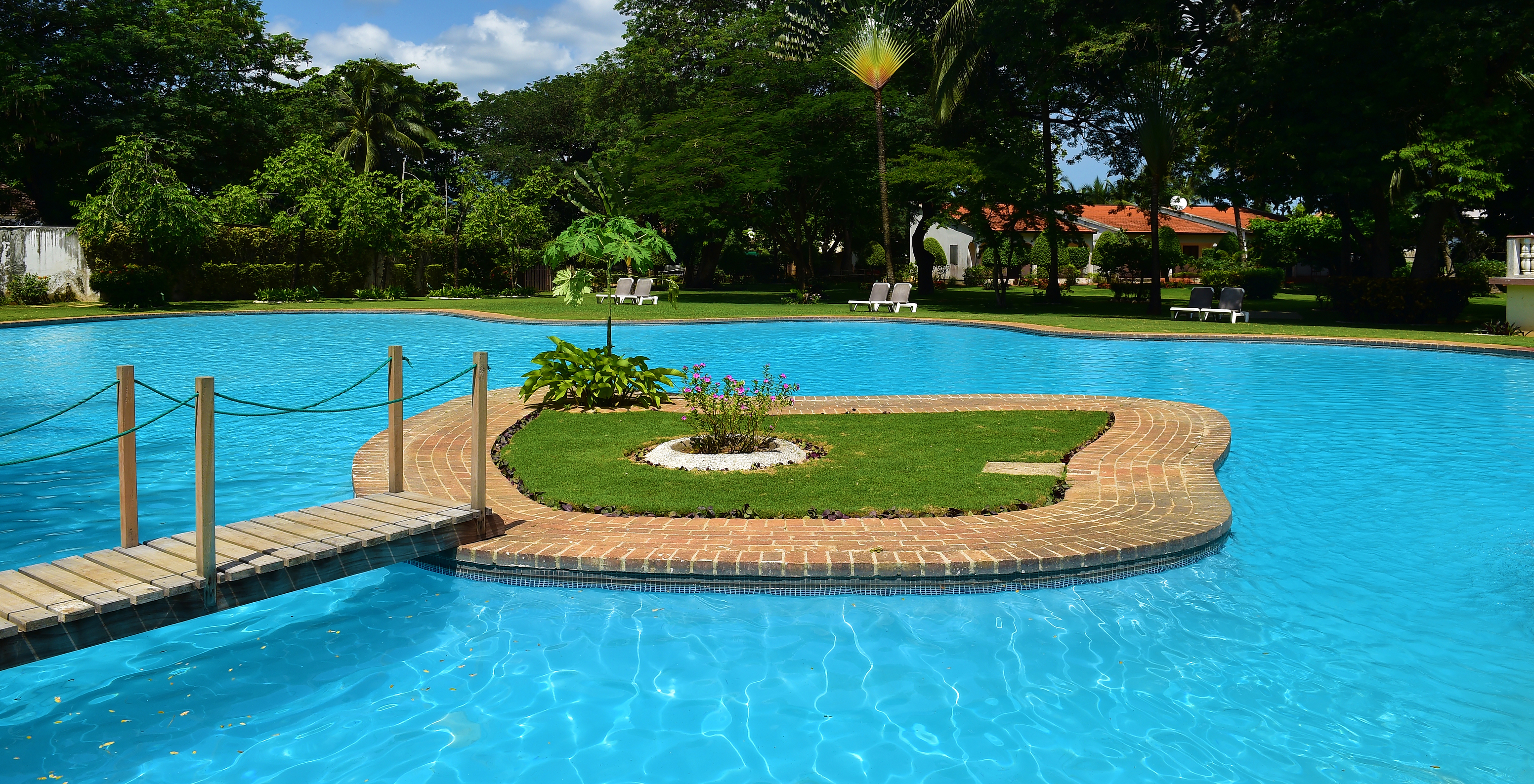 Outdoor pool of the hotel with pool, beachfront resembling a natural lake with crystal clear, deep blue water