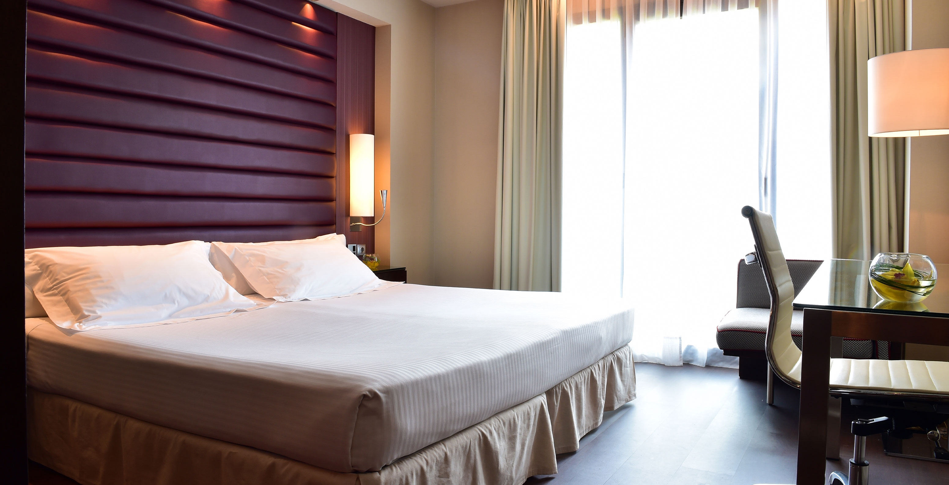 Premium King room at Pestana Arena Barcelona has a double bed, a desk, an ergonomic chair and a window