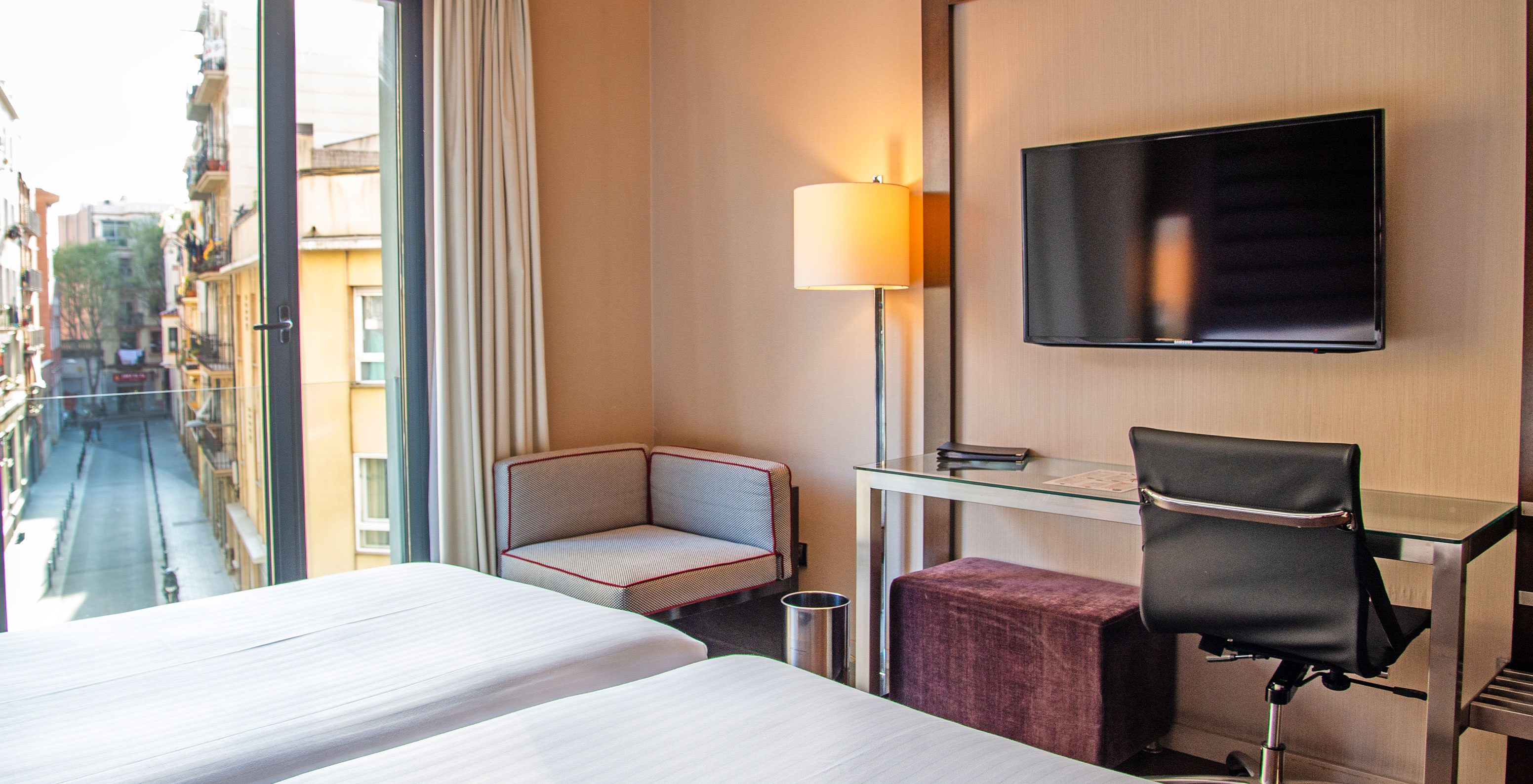 Standard Twin room at Pestana Arena Barcelona has a desk, TV, and a window overlooking the city center