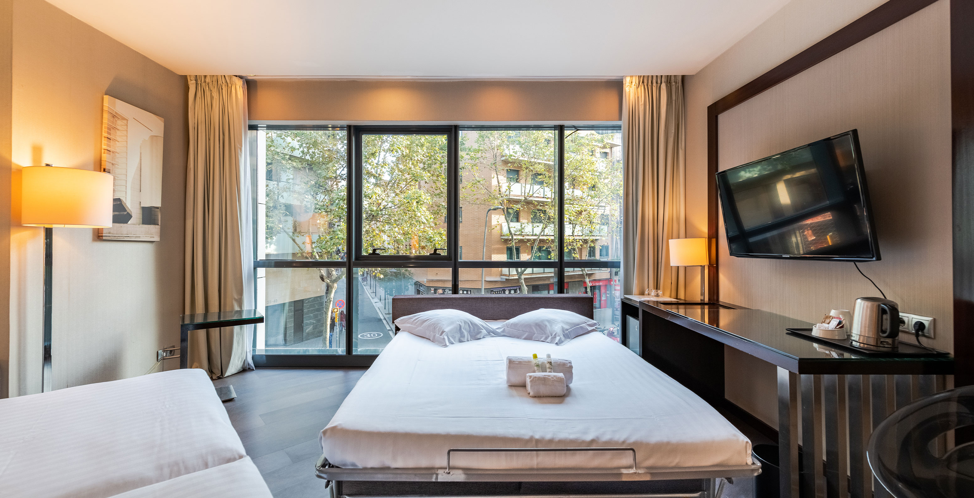 Large Family Room at Pestana Arena Barcelona has a room with a third bed, a TV and a desk