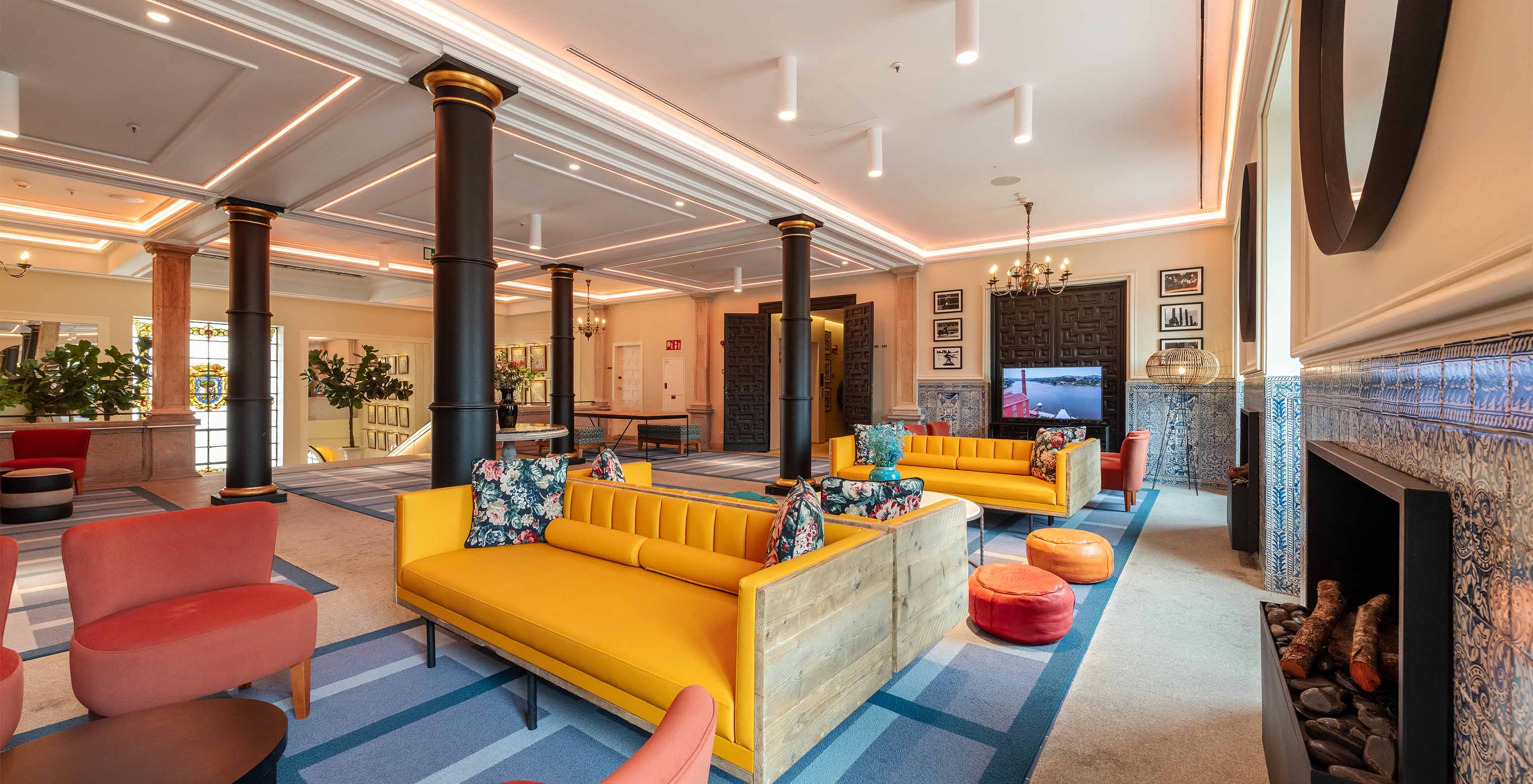 Lounge with four columns in the hotel with pool at Plaza Mayor in Madrid, with various colorful sofas and windows