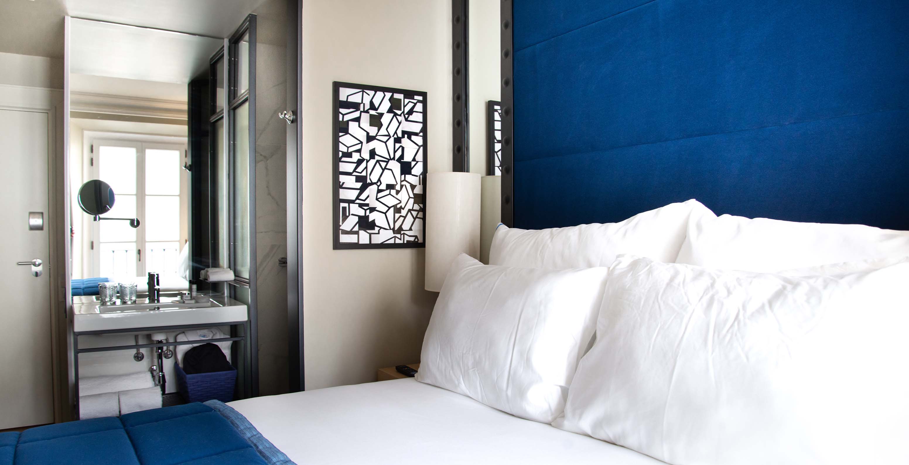 The Classic Room at Pestana Plaza Mayor Madrid has a double bed, a painting and bathroom with sink