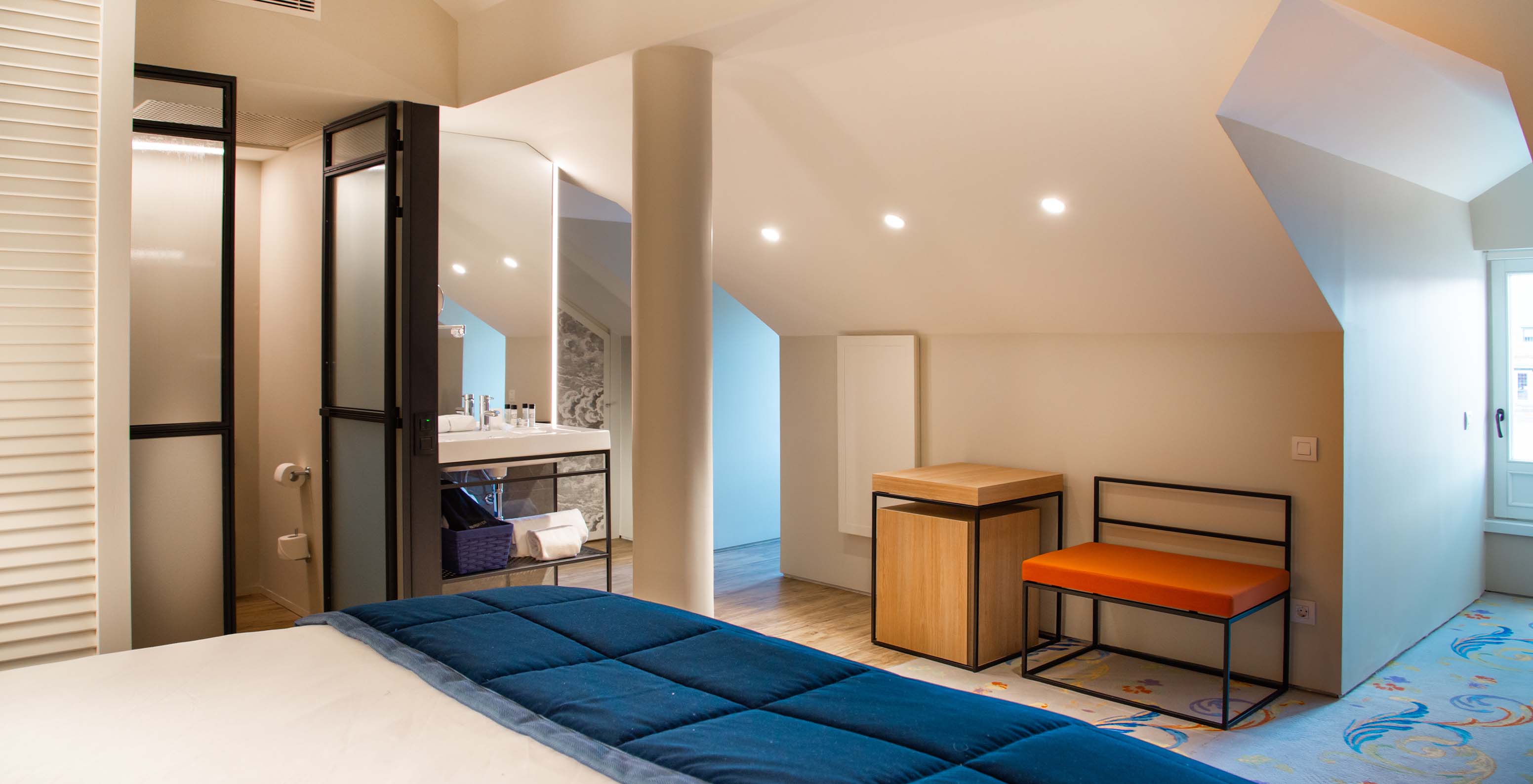 The Loft at Pestana Plaza Mayor Madrid has a double bed, a sink inside the room and a side table