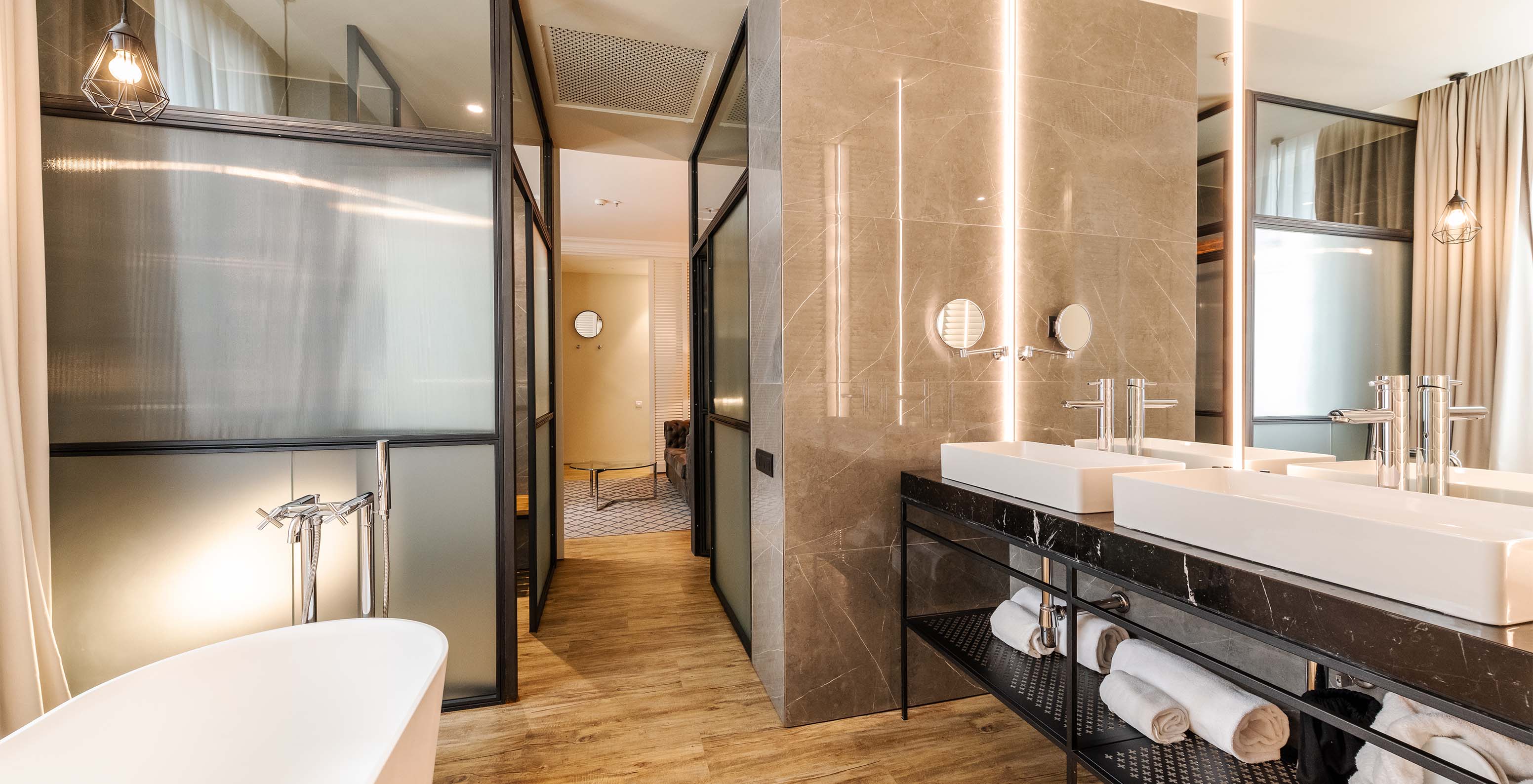 The Suite at Pestana Plaza Mayor Madrid has a large bathroom with two sinks, mirror and bathtub