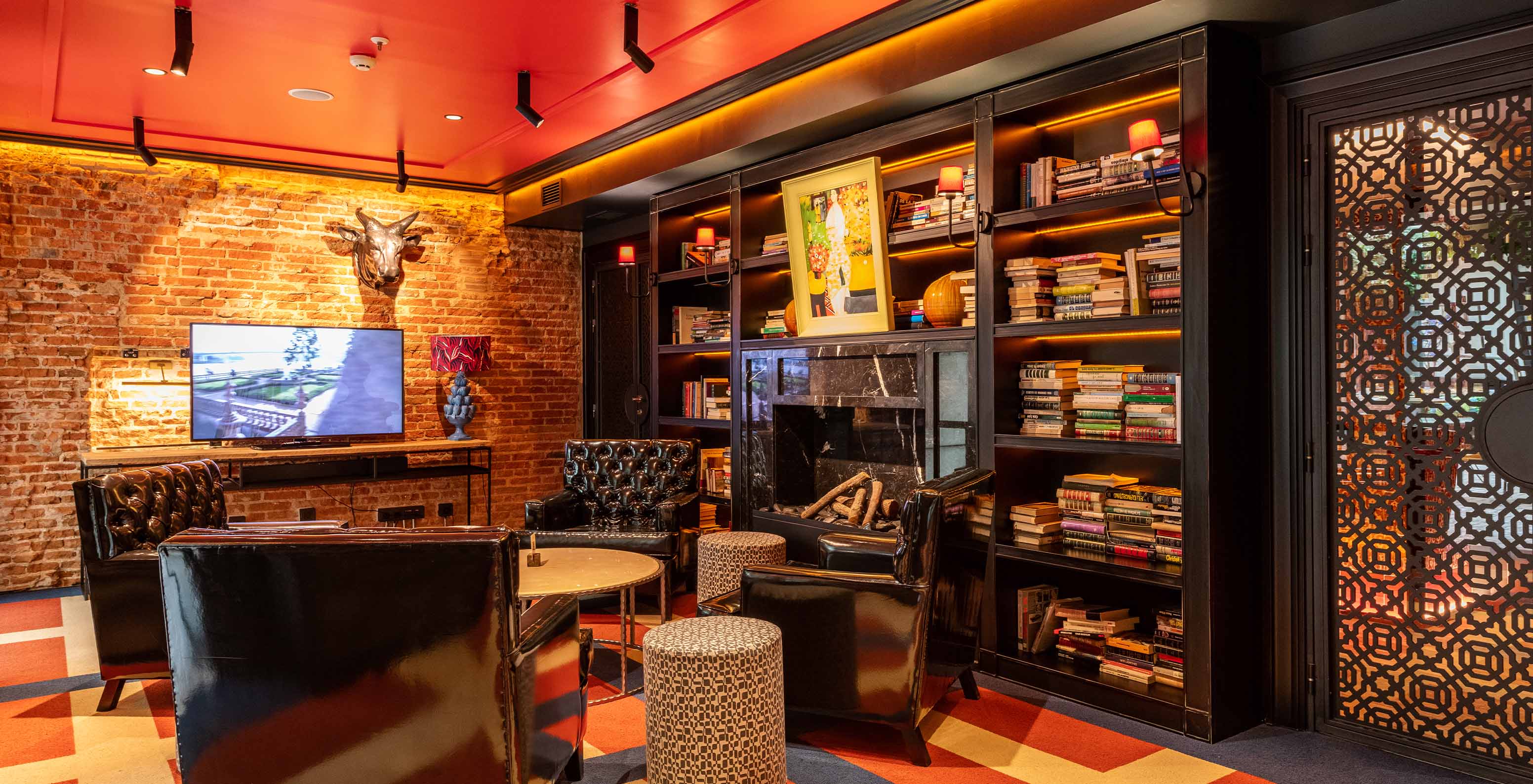 Hotel lobby with pool at Plaza Mayor in Madrid, with comfortable black sofas, television, and a small library