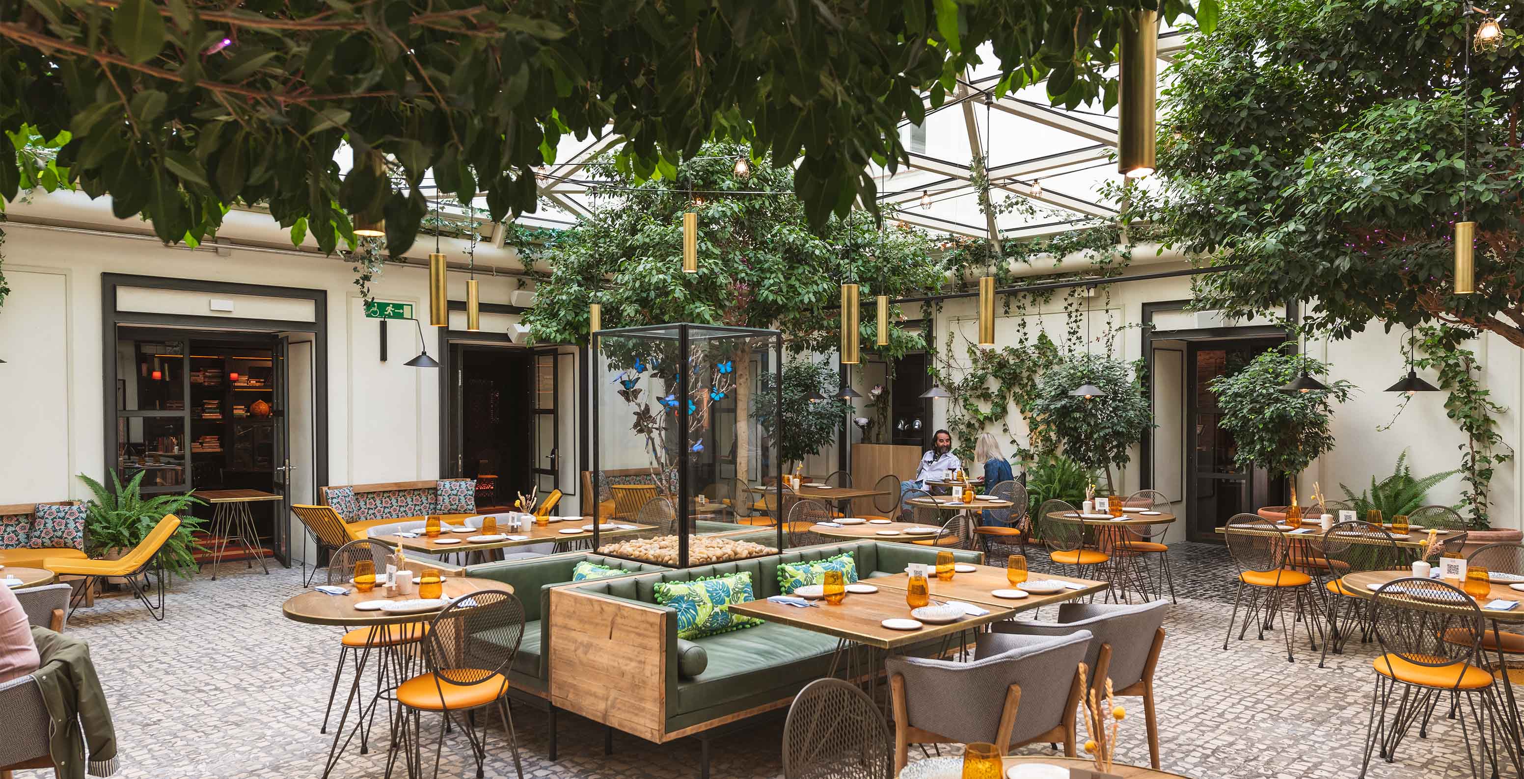 The Café de La Plaza restaurant at the Historic Center Hotel in Madrid features an inner courtyard surrounded by greenery