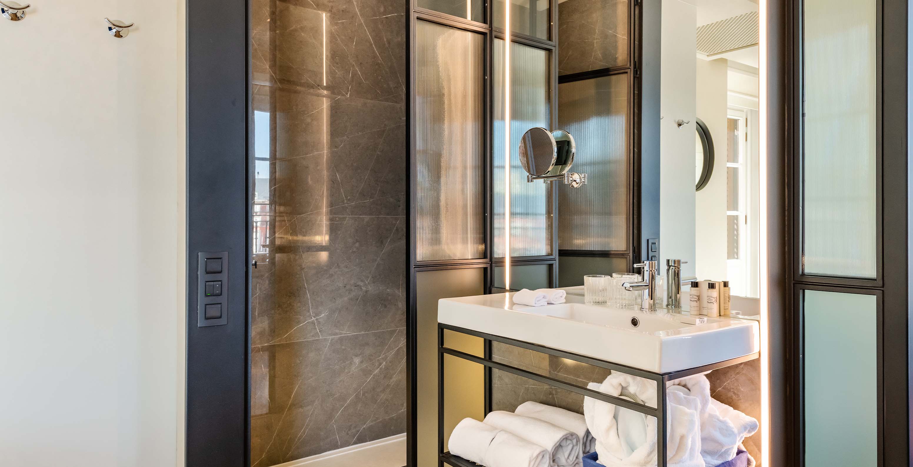 The Deluxe Plaza Mayor at Pestana Plaza Mayor Madrid has a bathroom with shower, sink, mirror, towels and amenities