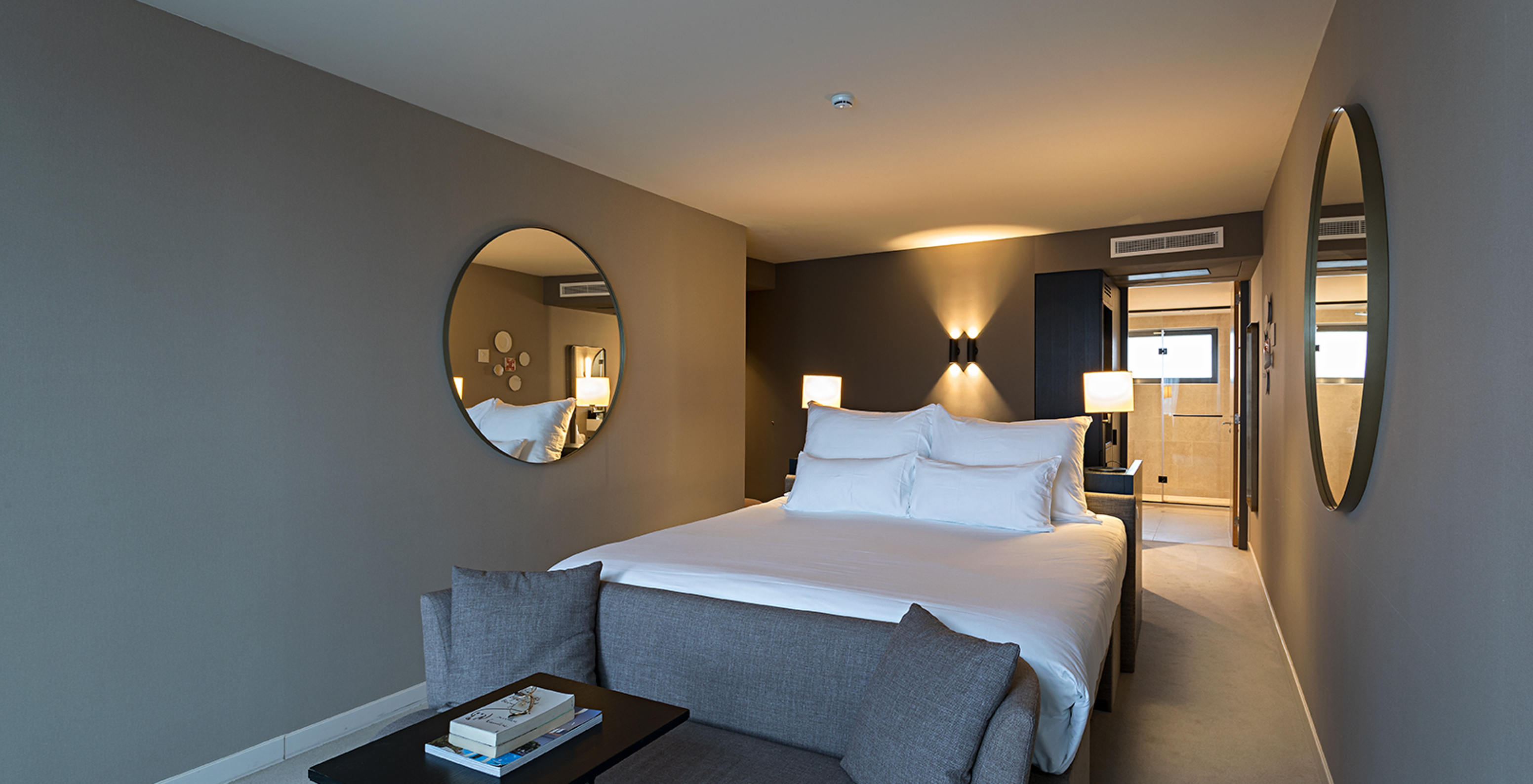 Executive - River View room at Pestana Amsterdam Riverside has a double bed, with a sofa in front and mirror