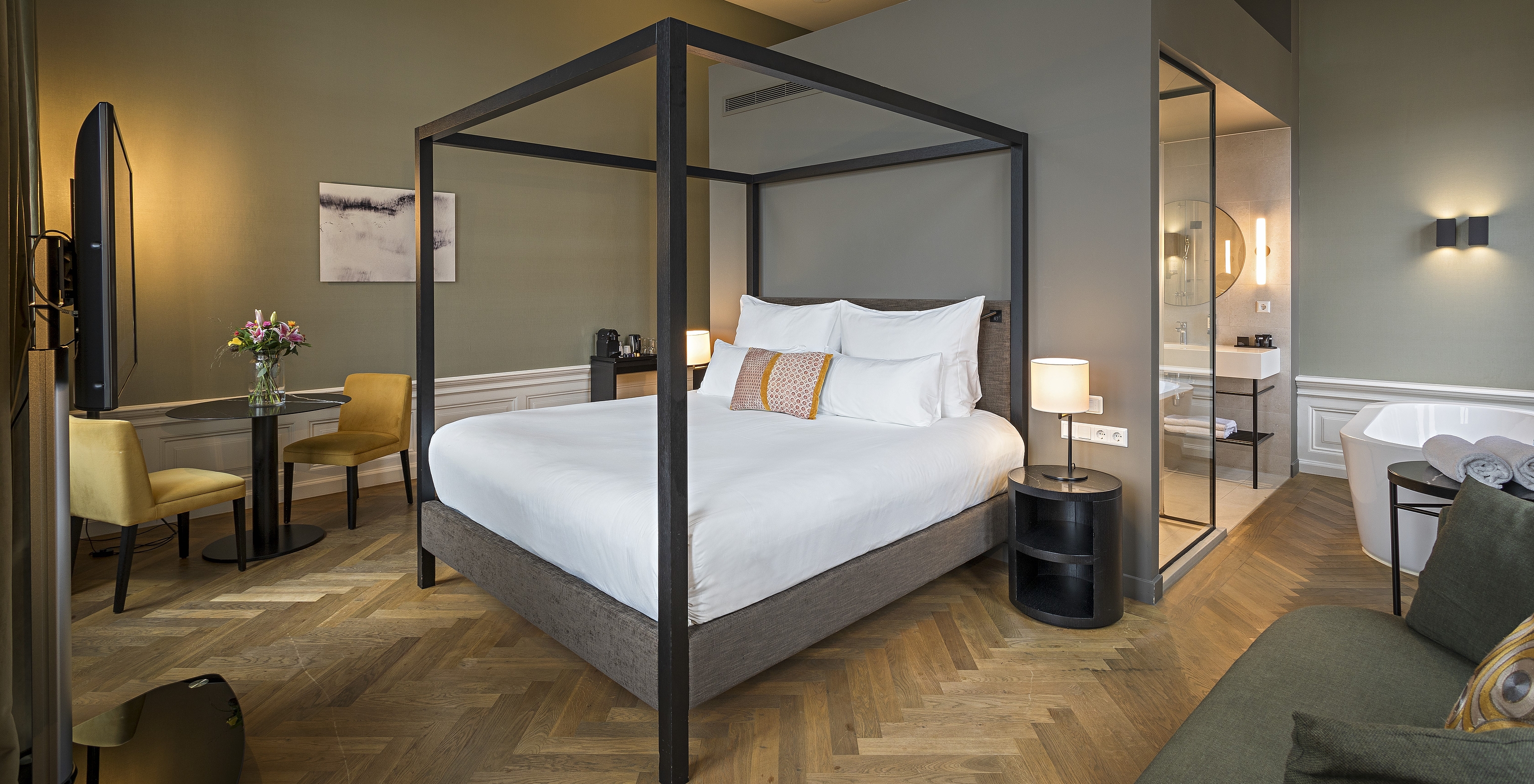 Junior Suite - River View at Pestana Amsterdam Riverside has a double bed with canopy and a table with two chairs