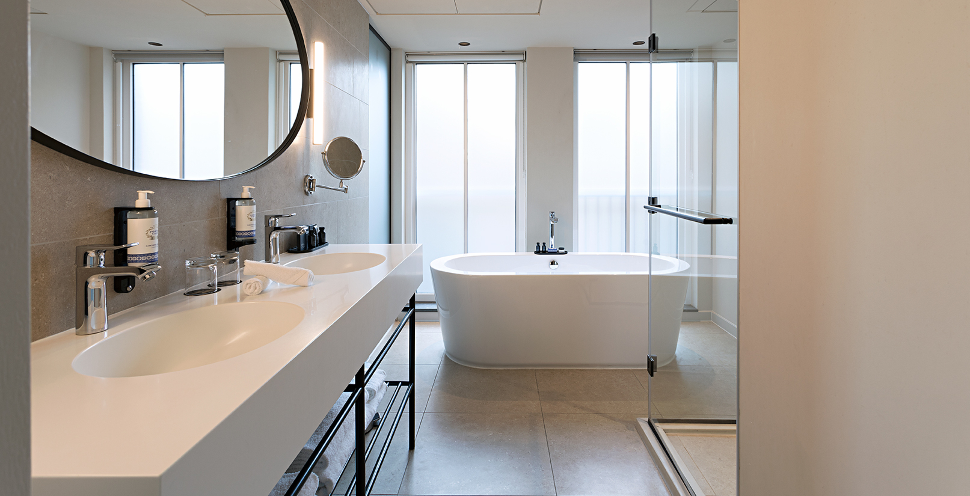 Premium - River View room at Pestana Amsterdam Riverside has a bathroom with mirror, two sinks and bathtub