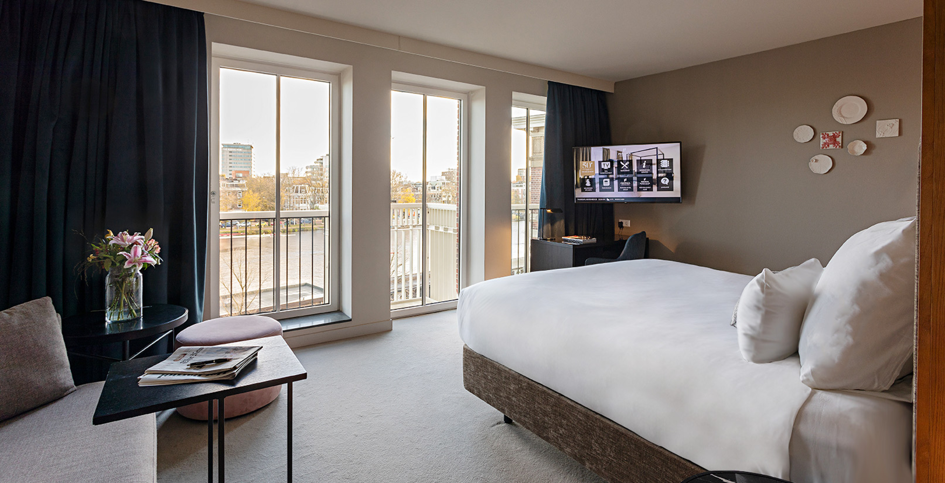 Premium - River View room at Pestana Amsterdam Riverside has large glass windows, with a view of the river, and a table